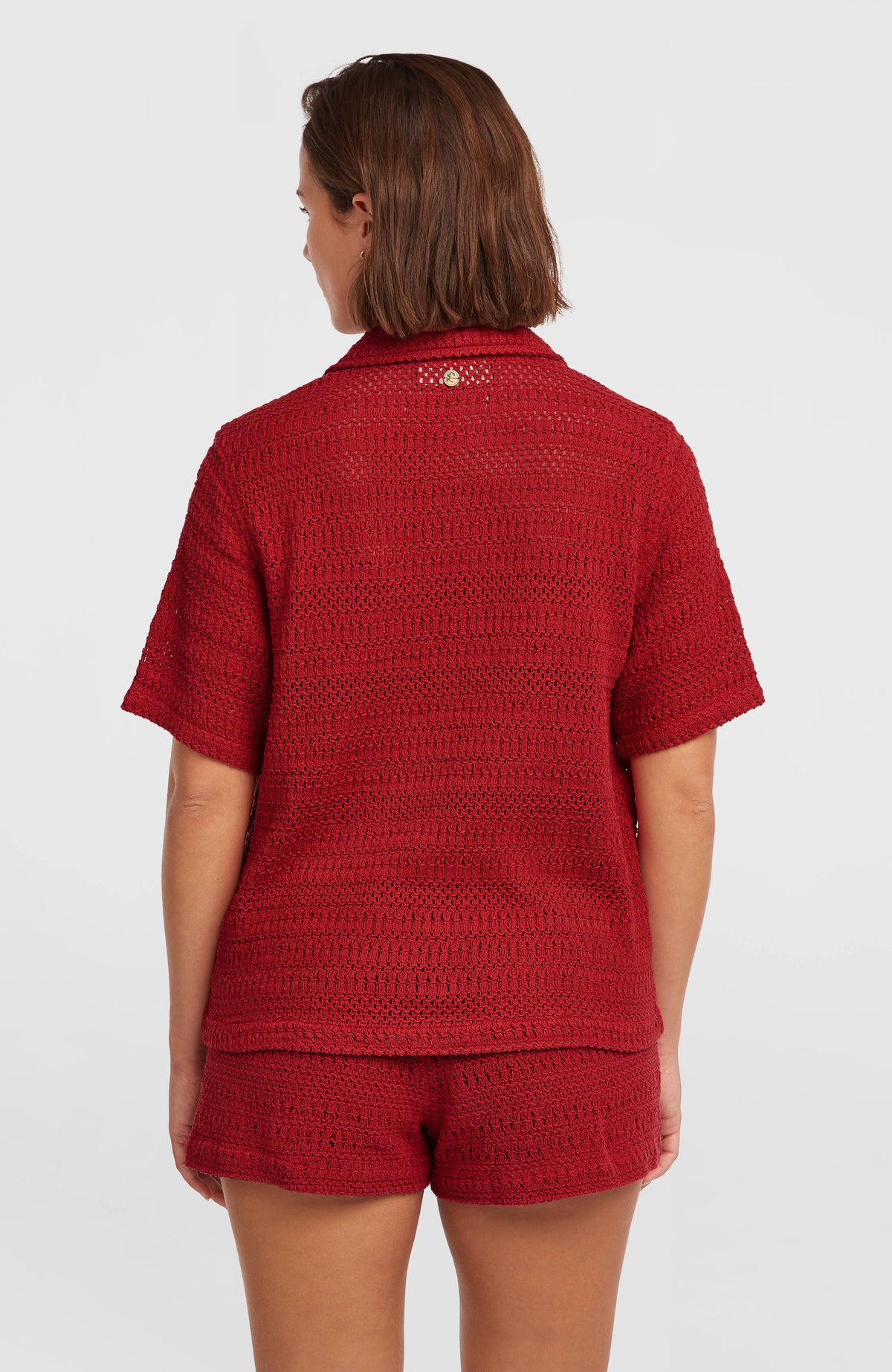 O'Riginals Häkelbluse für Damen, rot, Rückansicht am Model mit kleinem Logo-Badge unterhalb des Kragens
