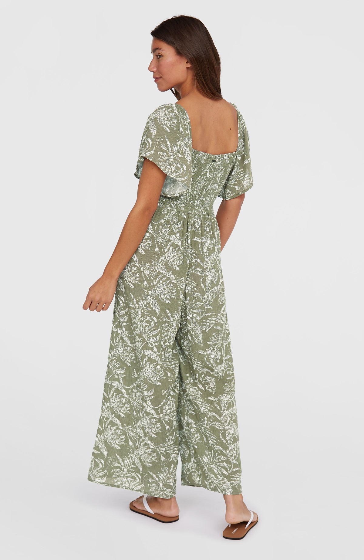 Kesia Jumpsuit für Damen, grün mit Dschungelmuster in Weiß, getragen am Model von hinten