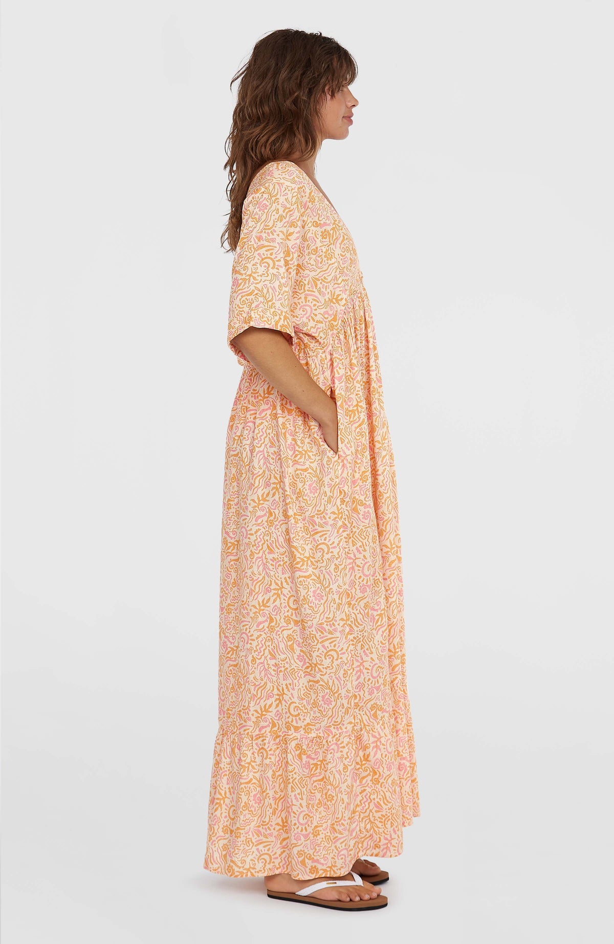 Women of the Wave Maxikleid für Damen, weiß mit Wellenmuster in Gelb und Rosa, Seitenansicht am Model mit Eingrifftasche