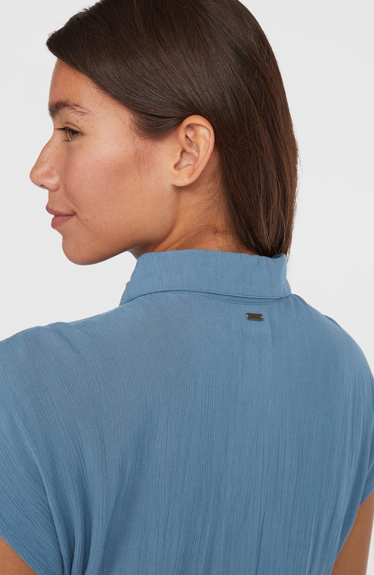 Nahaufnahme von Kragen und Logo-Badge an der Rückseite des blauen Lori Maxi-Hemdkleids