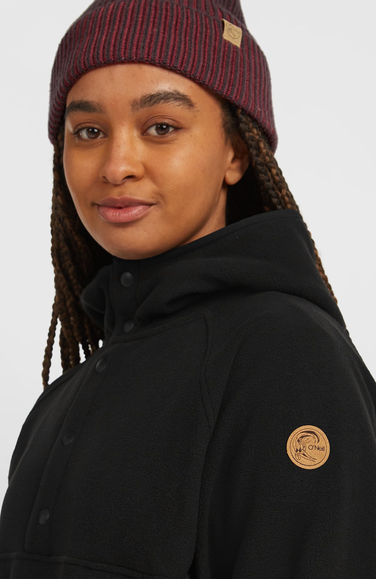 O'Riginals Superfleece Hoodie für Damen, schwarz, Nahaufnahme am Model mit runder Logo-Applikation am Ärmel