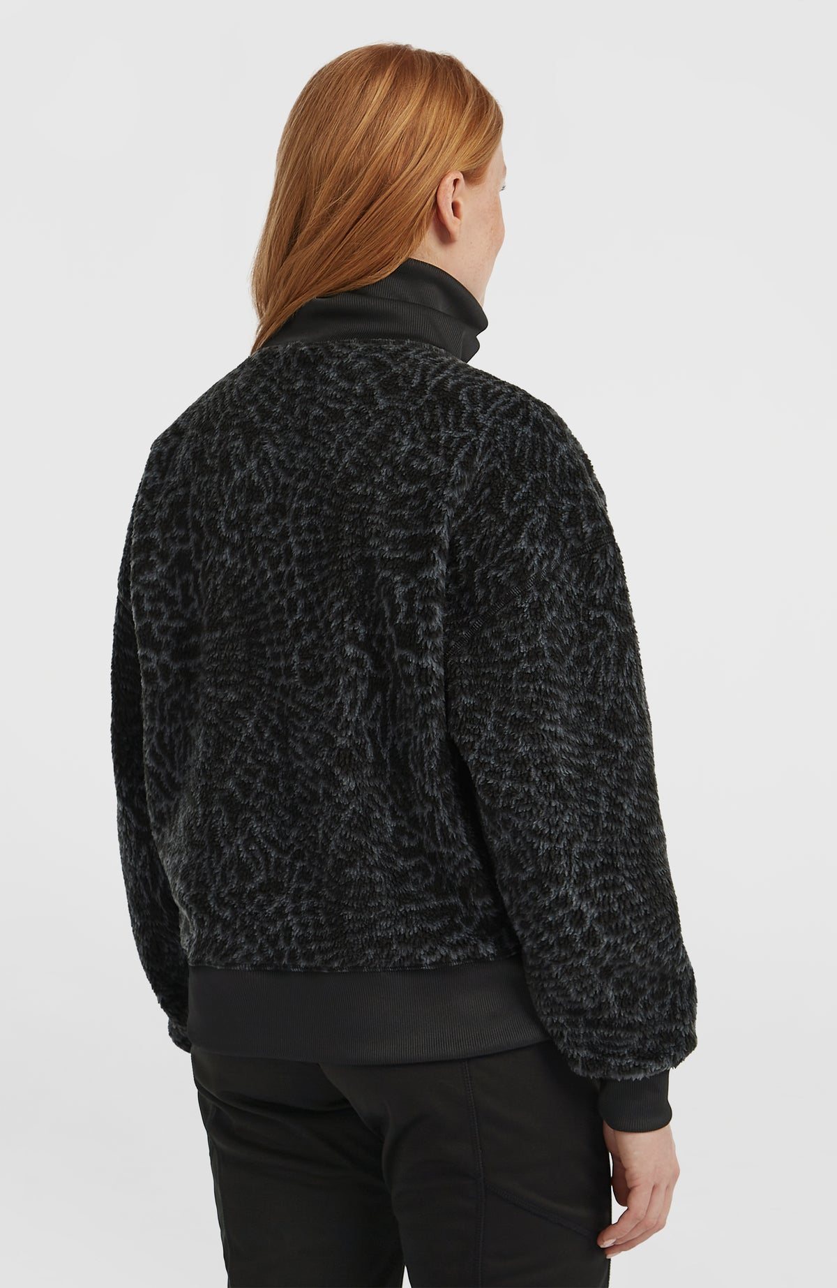 Must-Have Fleecepullover für Damen, schwarz mit Tiermuster in Grau, Rückansicht am Model mit geripptem Saumbund