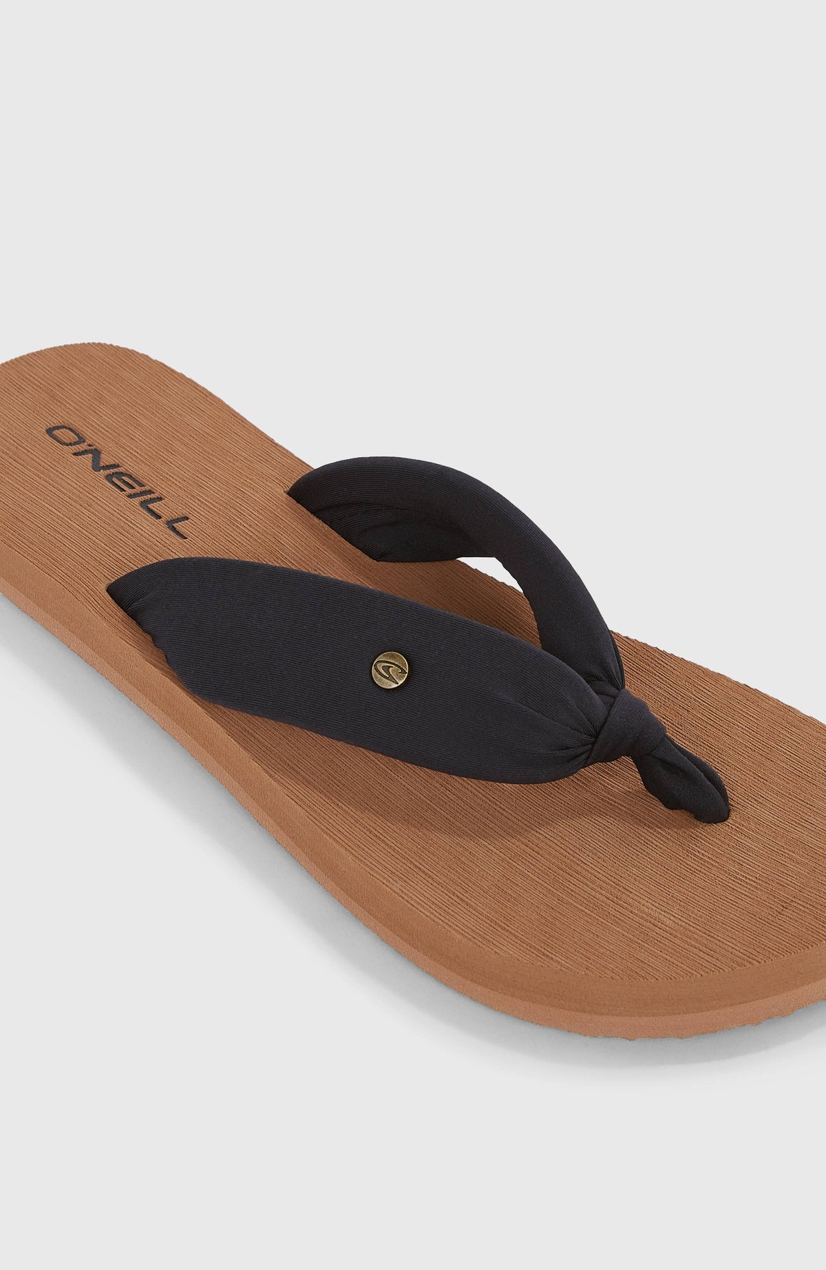 Nahaufnahme der schwarzen Ditsy Sun Sandalen für Damen mit geknotetem Riemen und Logo-Pin