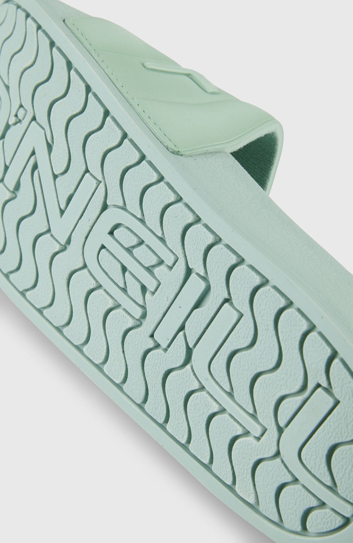 Nahaufnahme der strukturierten Laufsohle der grünen Embossed Slides für Damen