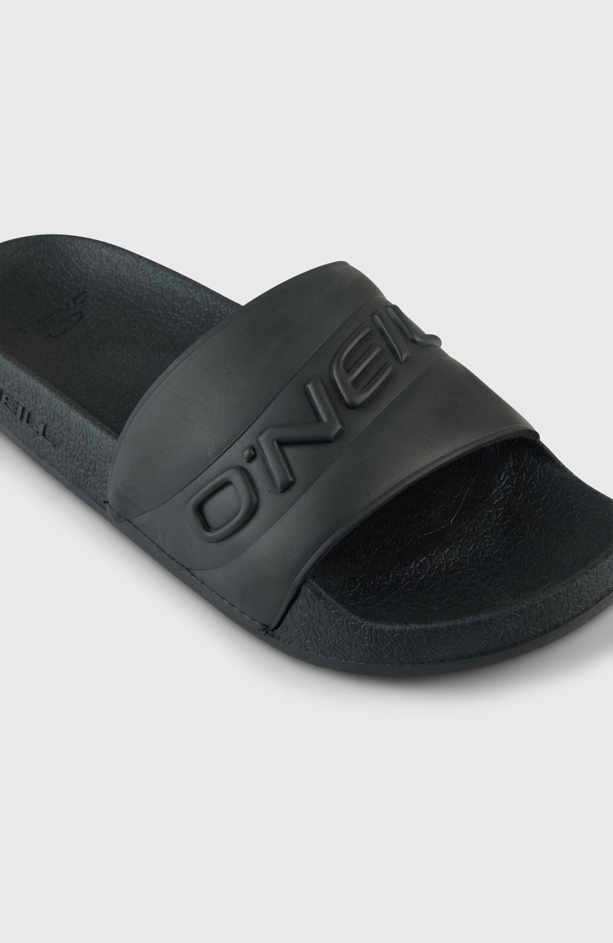 Nahaufnahme des Riemens mit Logoprägung der schwarzen Embossed Slides für Damen
