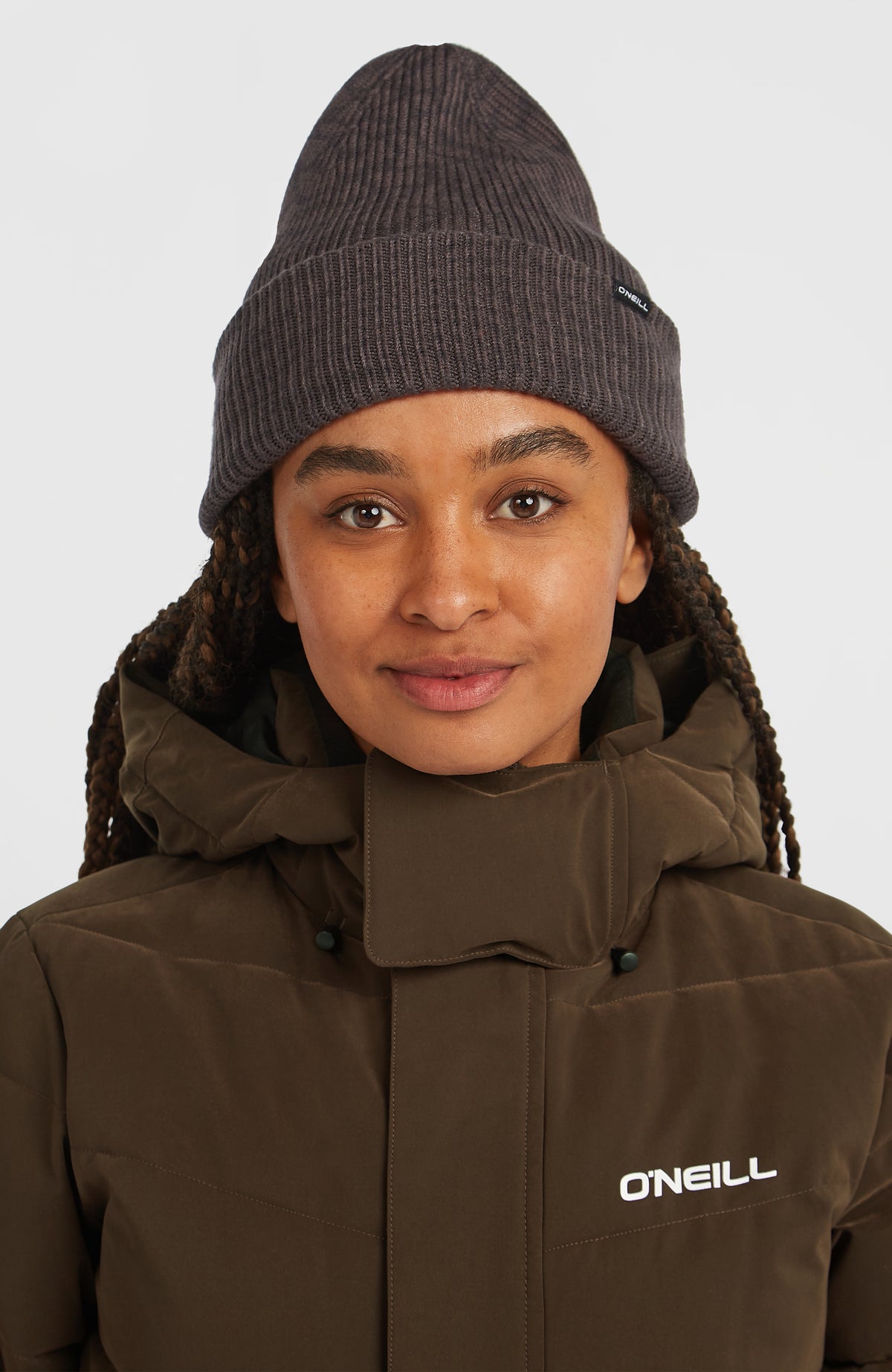 FWC'Cruz Beanie für Damen, schwarz, getragen am Model in Vorderansicht mit sichtbarem Logo-Patch am Umschlag