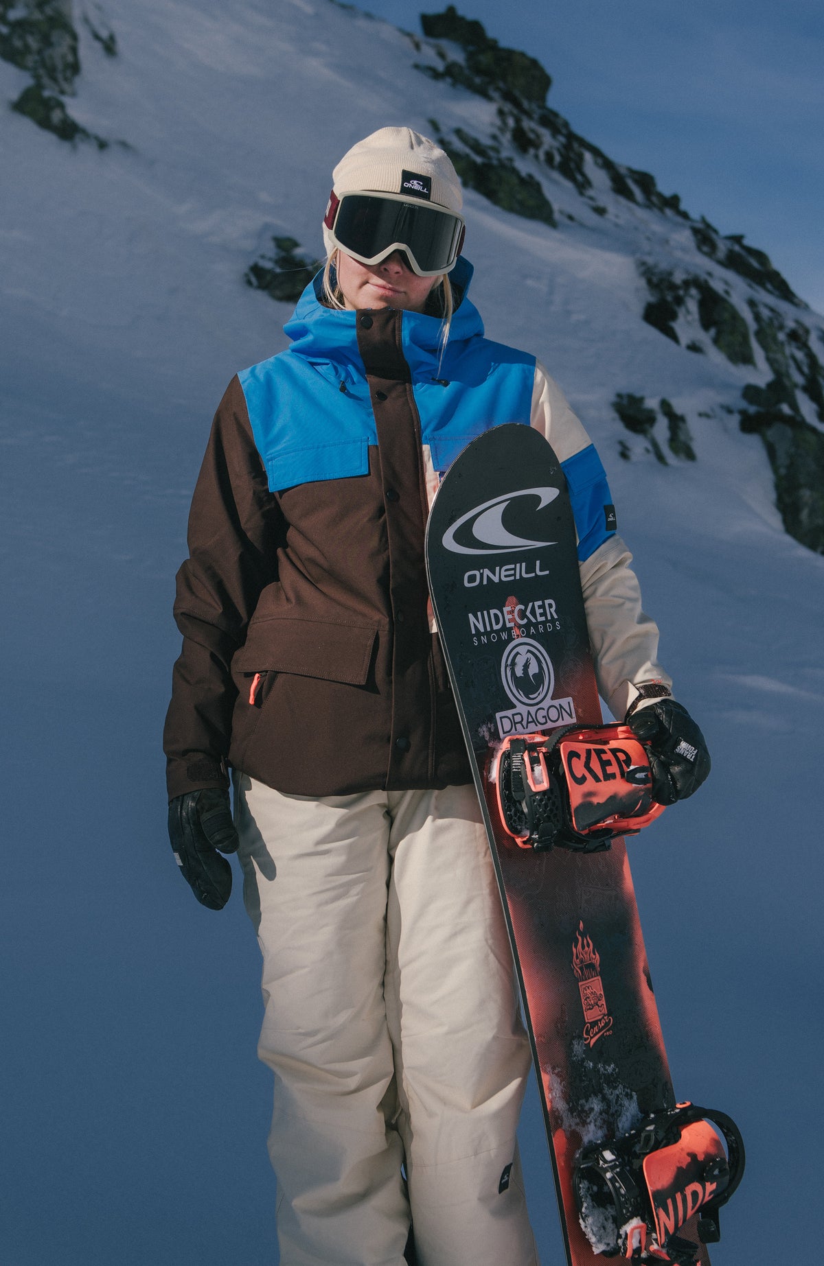 FWC'Peak Pro Skijacke für Damen in Blau, getragen am Model im Schnee, Frontansicht mit Snowboard