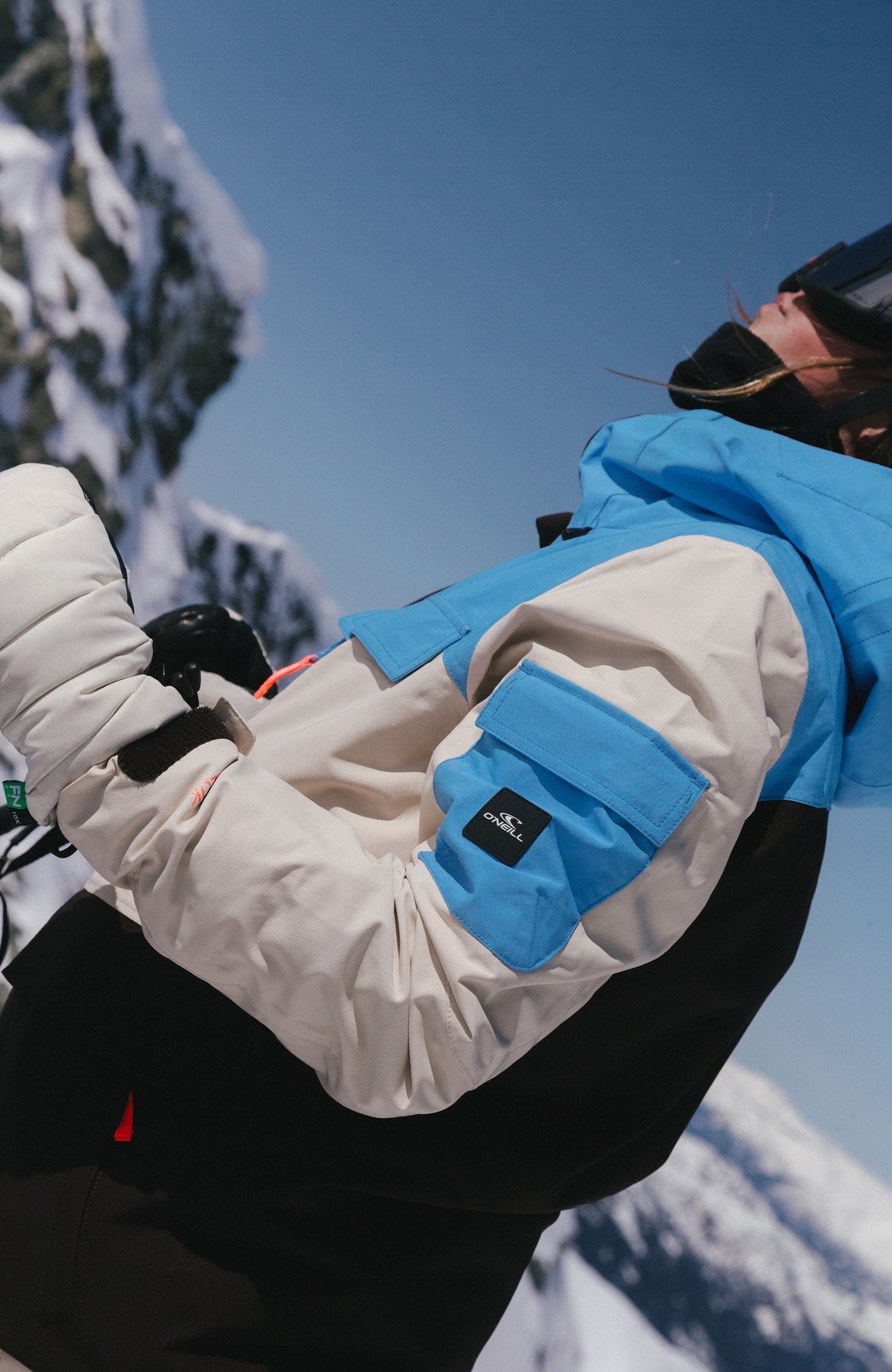 FWC'Peak Pro Skijacke für Damen in Blau, Nahaufnahme der Ärmeltasche mit Logo-Patch im Schnee