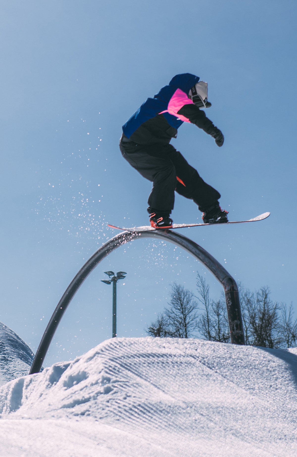 FWC'Play Asymmetric Jacke für Damen, blau, getragen am Model im Schnee bei einem Sprung