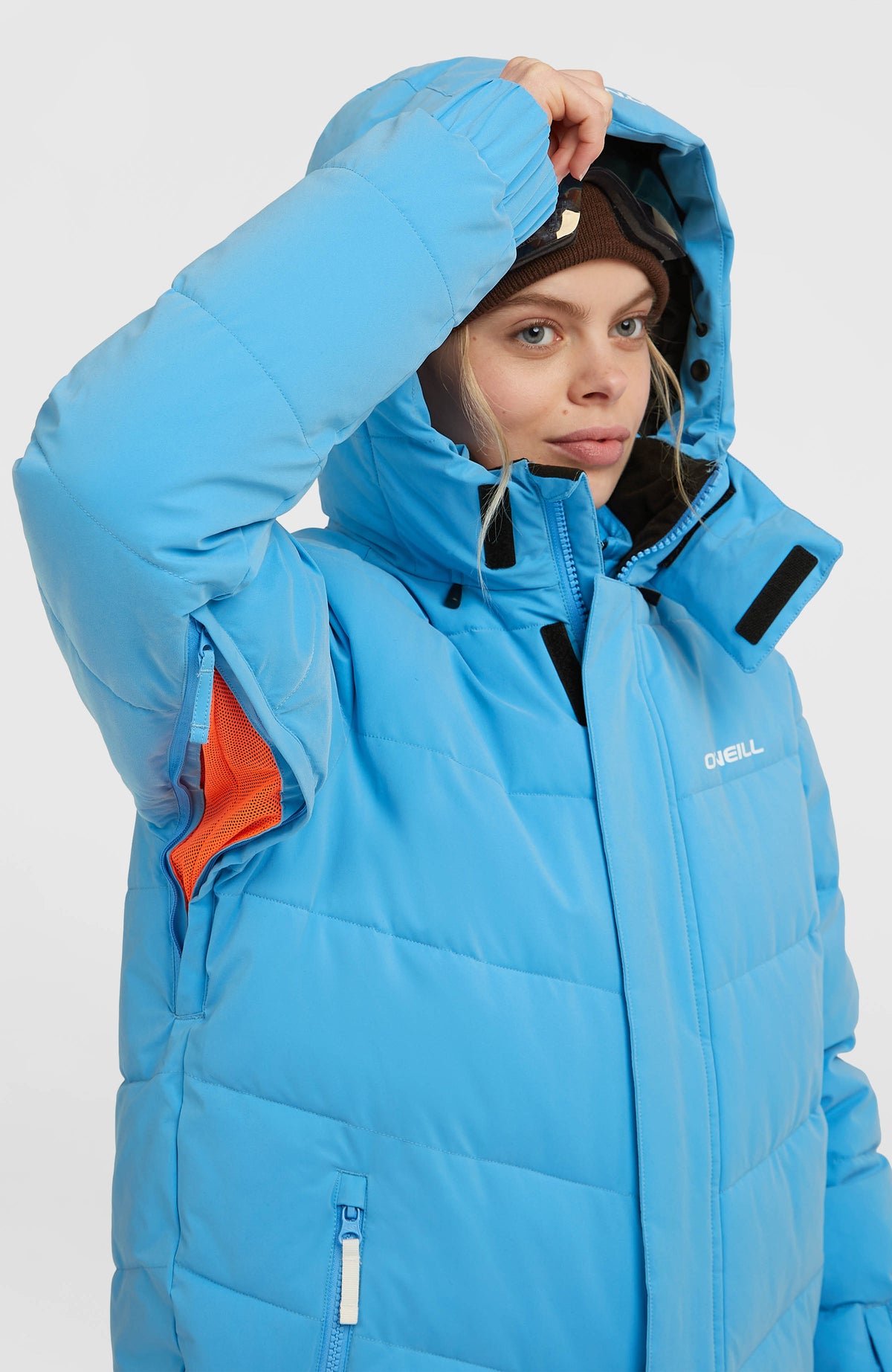 Gesteppte FWC'Cruz Hybrid-Skijacke in Blau am Model, Belüftungsreißverschluss mit orangefarbenem Mesh