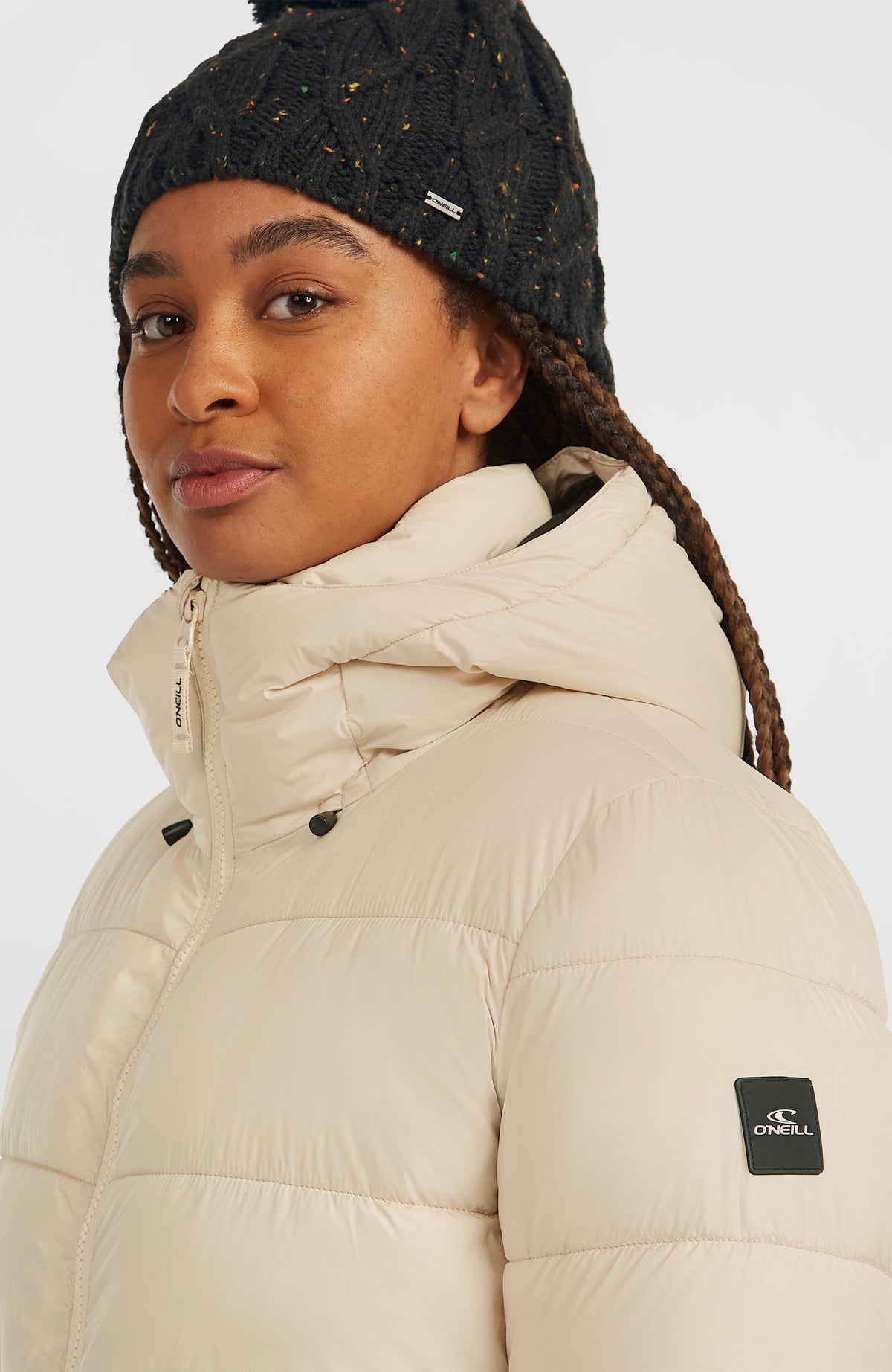 Lange Must-Have Steppjacke für Damen in Beige, Nahaufnahme von Stehkragen, Kapuze und Logo-Badge am Ärmel