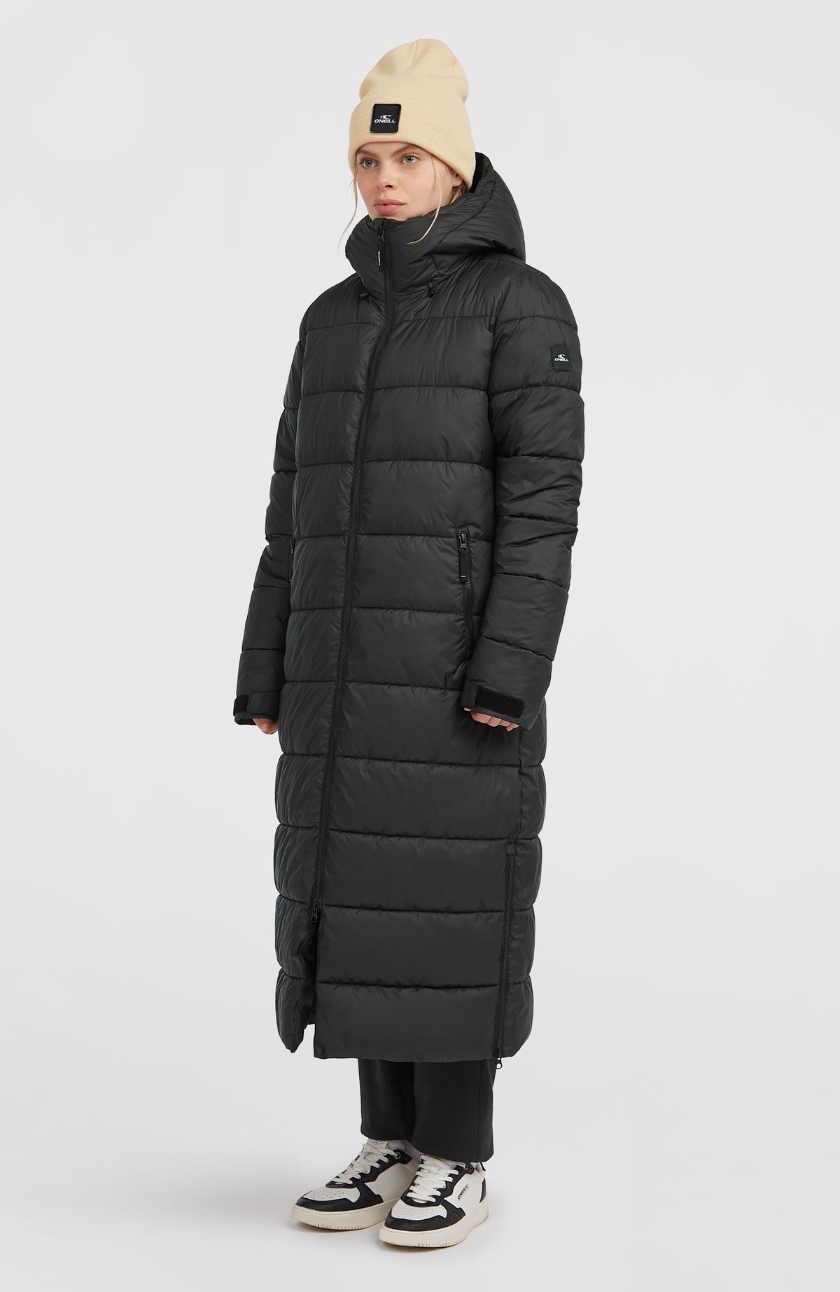 Lange Must-Have Steppjacke für Damen, schwarz, getragen am Model in Dreiviertelansicht mit Stehkragen