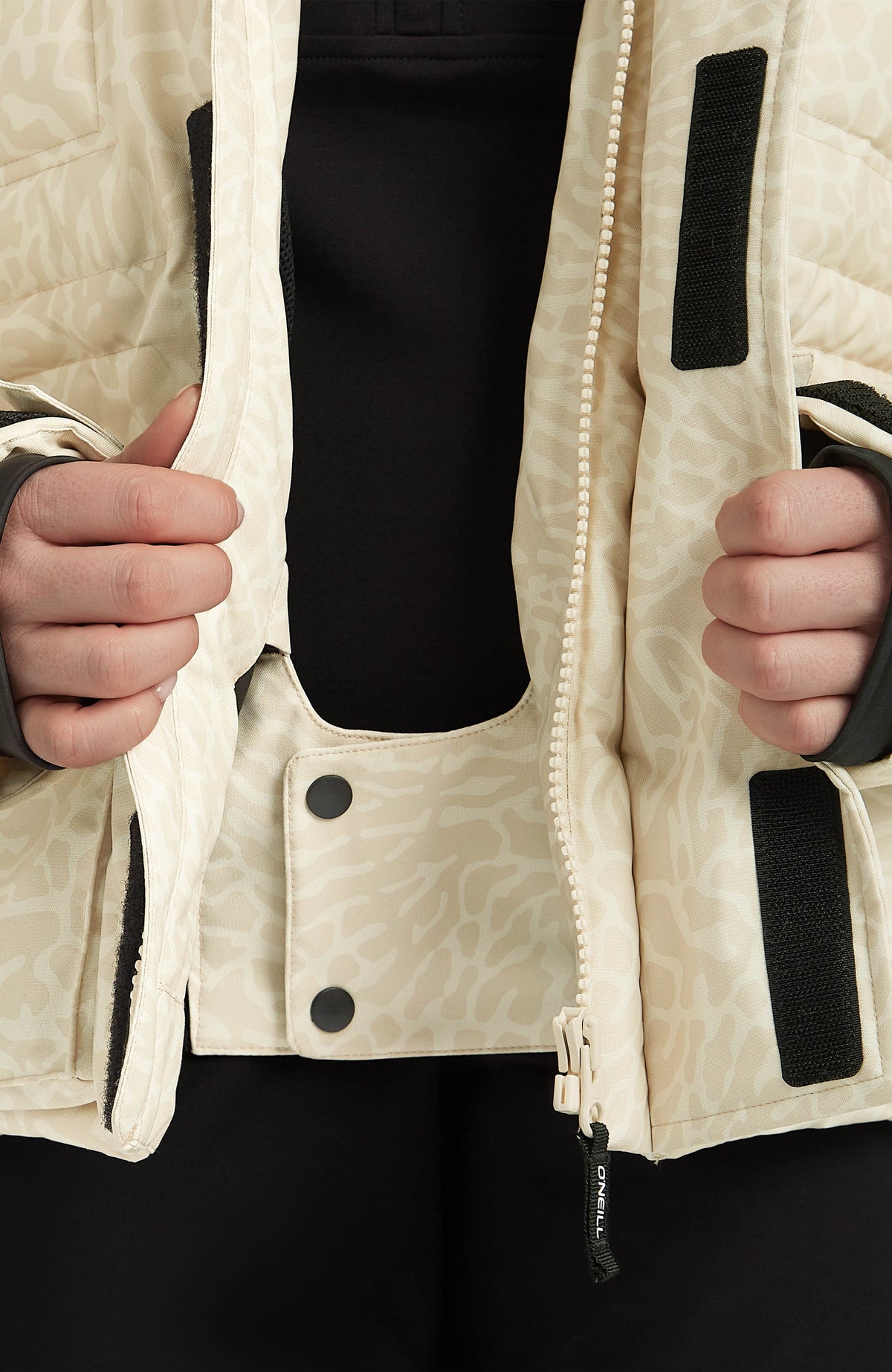 Nahaufnahme des integrierten Schneefangs der beigen FWC'Cruz Hybrid-Skijacke für Damen mit Tiermuster