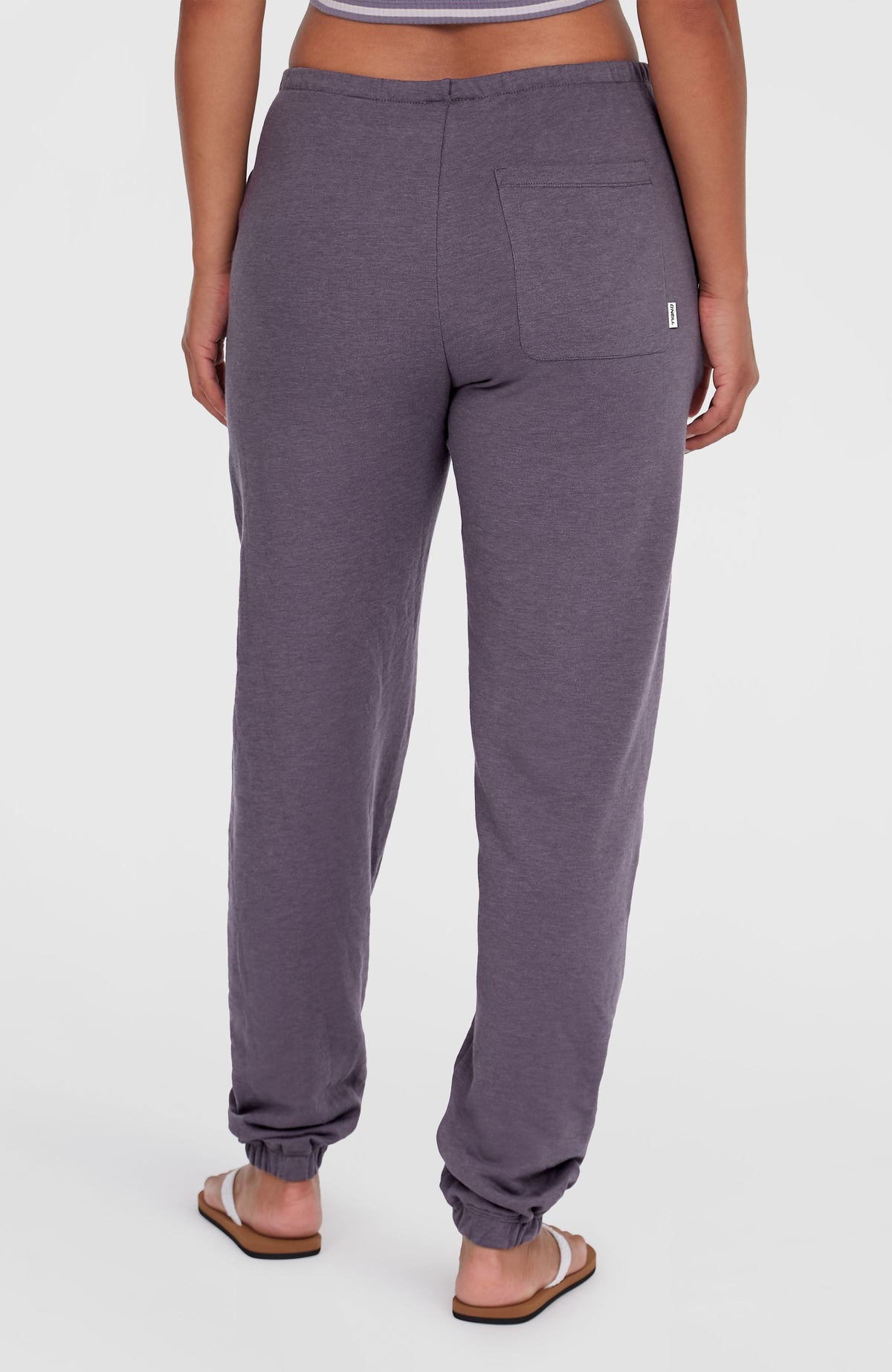 Essentials O'Neill Script Jogginghose für Damen, lila, Rückansicht am Model mit aufgesetzter Gesäßtasche und Label