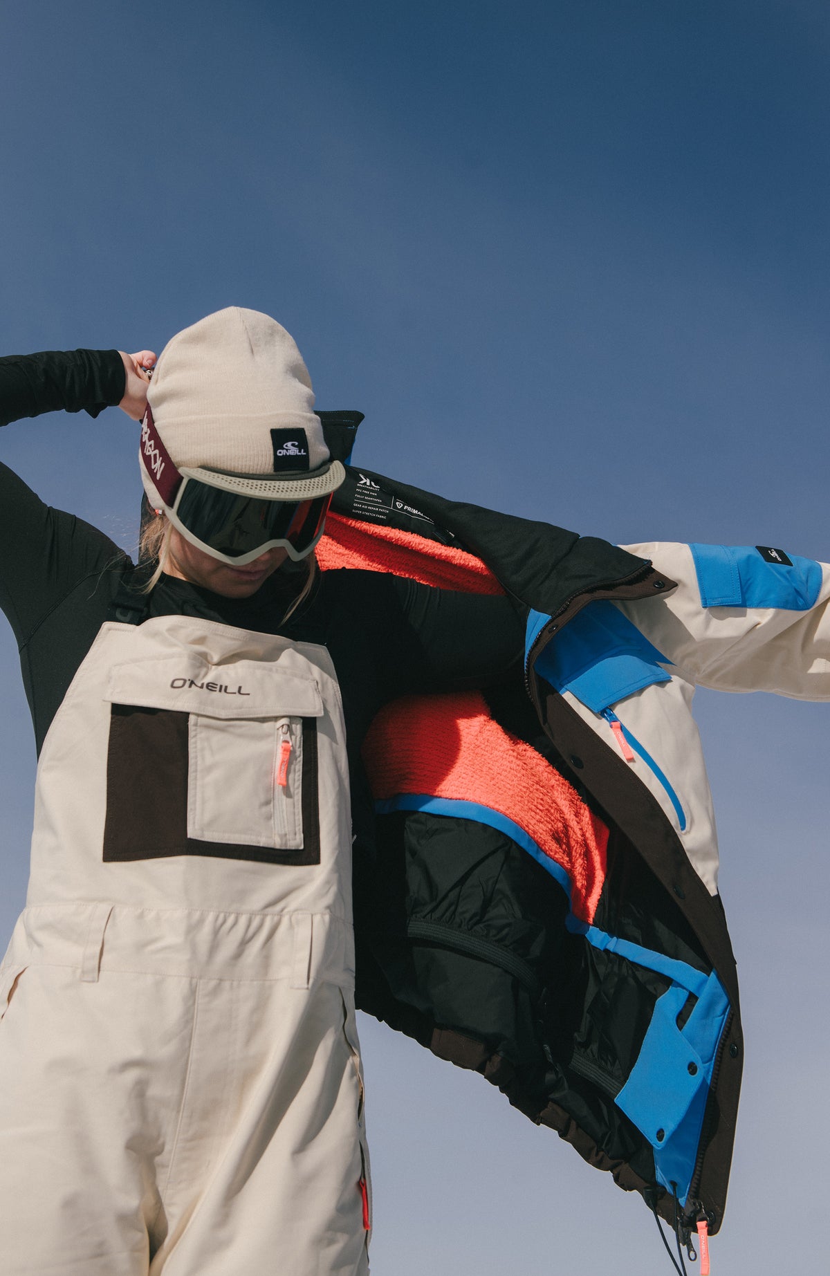 FWC'Peak Bib Skihose für Damen, beige, getragen am Model im Freien mit Skijacke und Brille