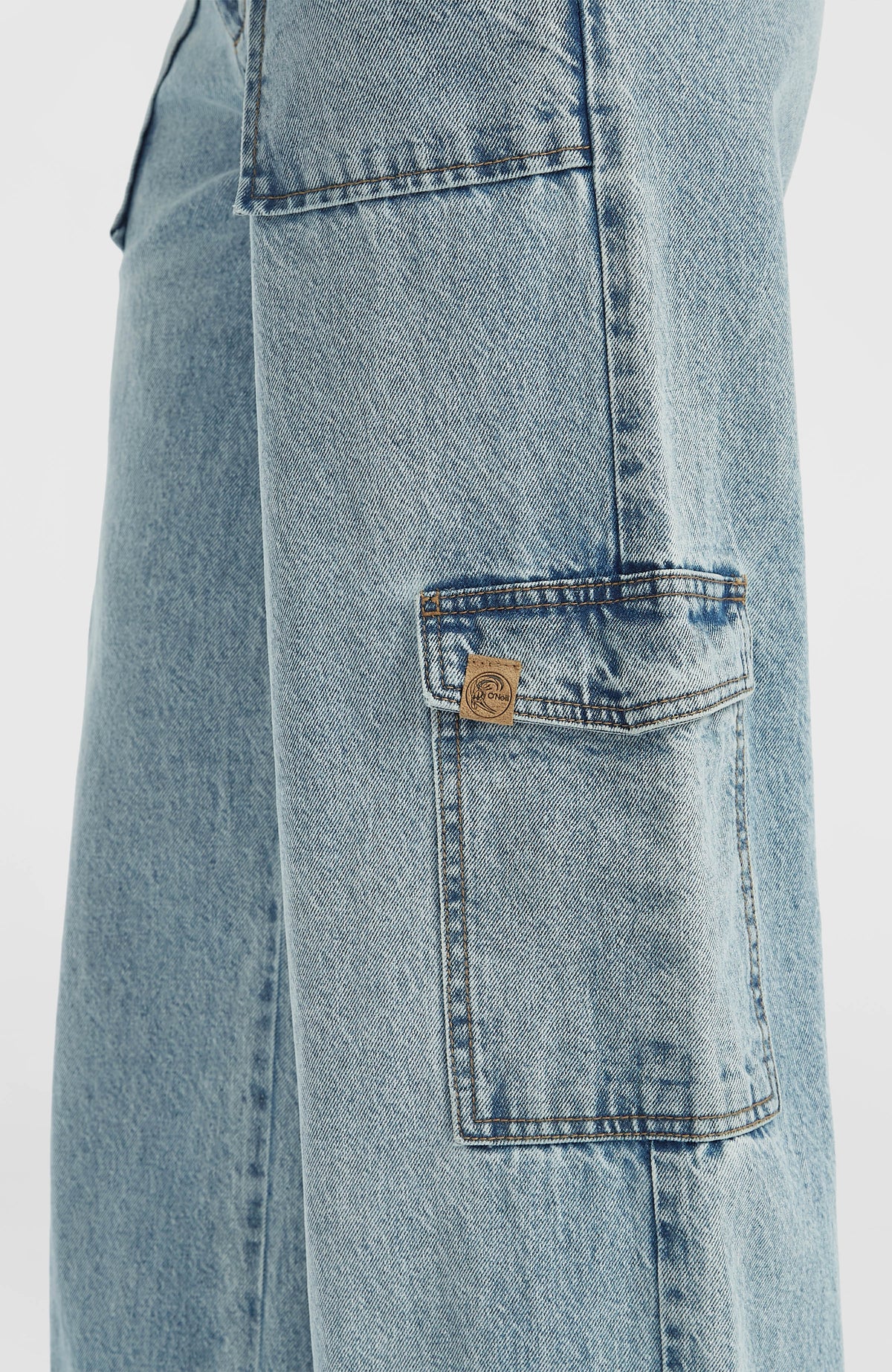 Nahaufnahme der blauen O'Riginals Denim-Cargohose mit Logo-Patch auf der seitlichen Cargotasche
