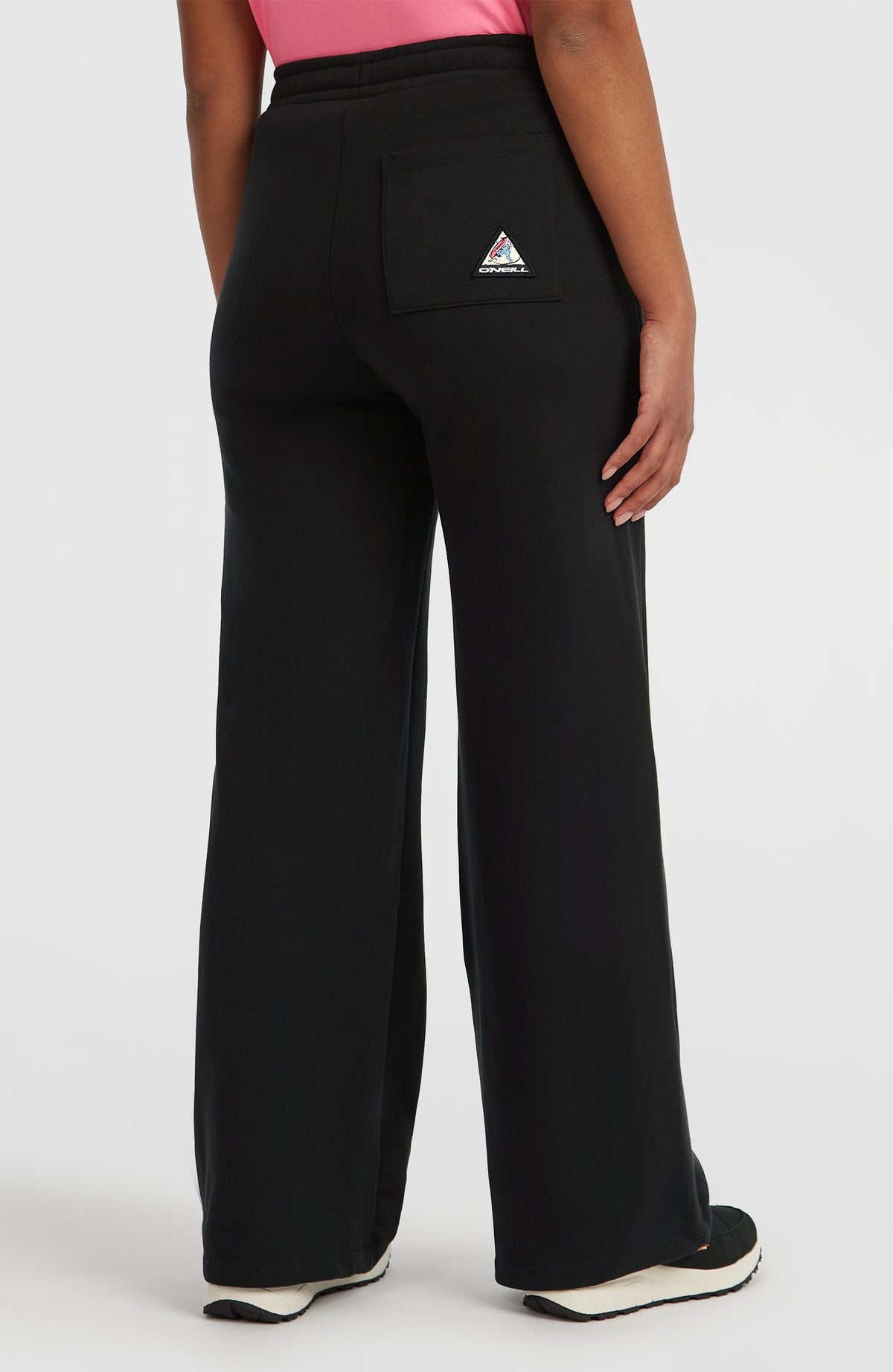 FWC'Play Jogginghose für Damen, schwarz, Rückansicht am Model mit aufgesetzter Tasche und Logo-Patch