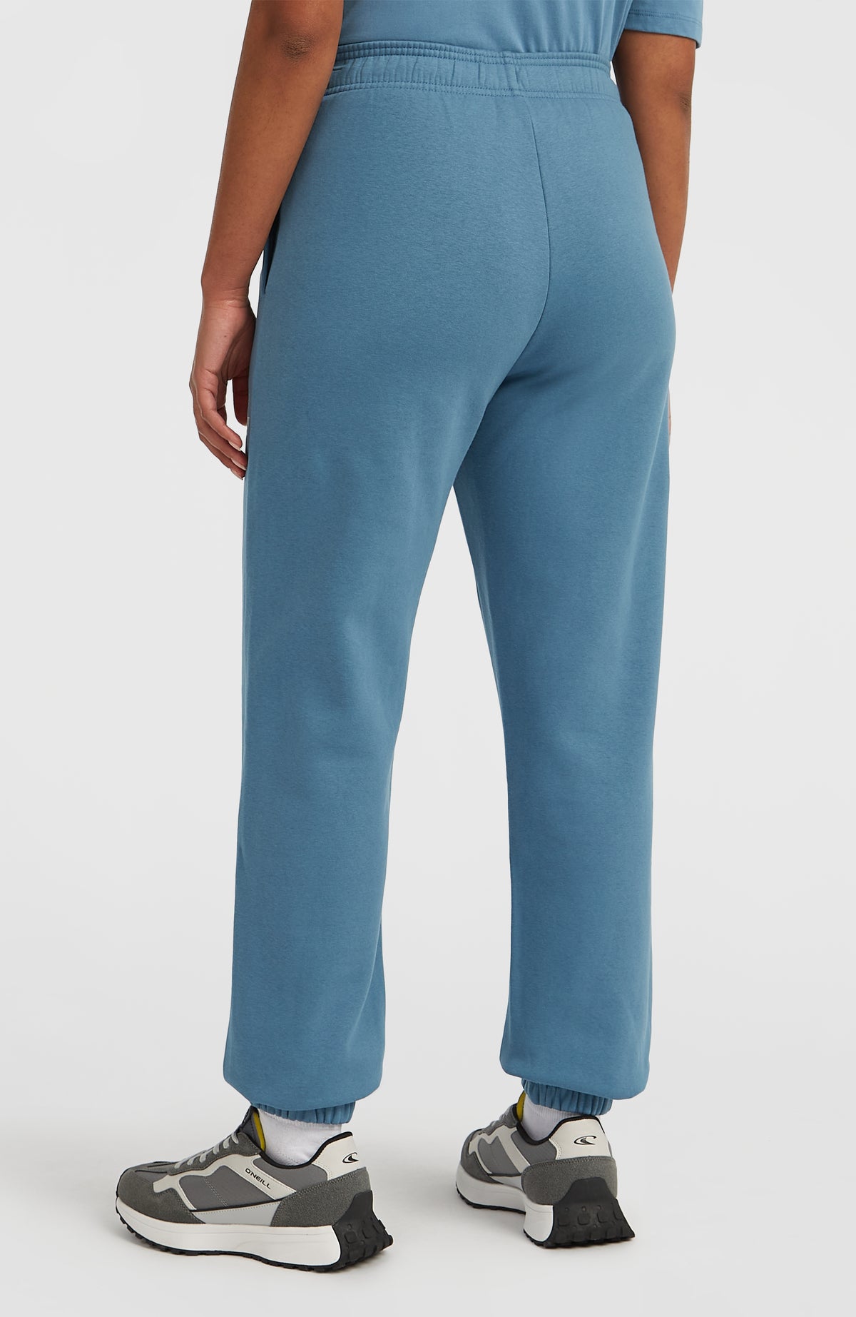 Future Surf Society Jogginghose für Damen, blau, Rückansicht am Model mit elastischen Beinabschlüssen