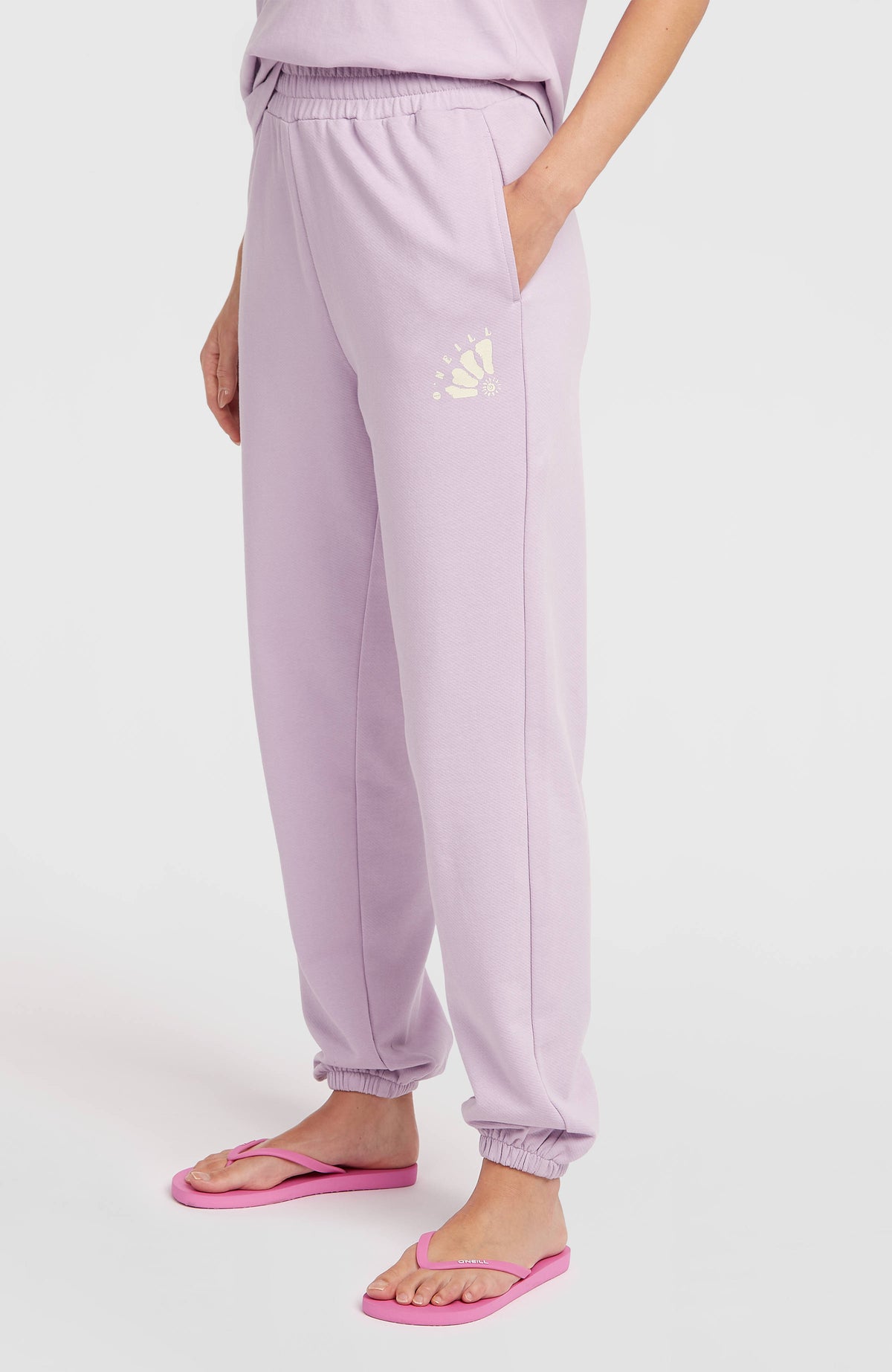 Women of the Wave Jogginghose für Damen, lila mit Logo-Print in Gelb, Seitenansicht am Model, elastischer Saum