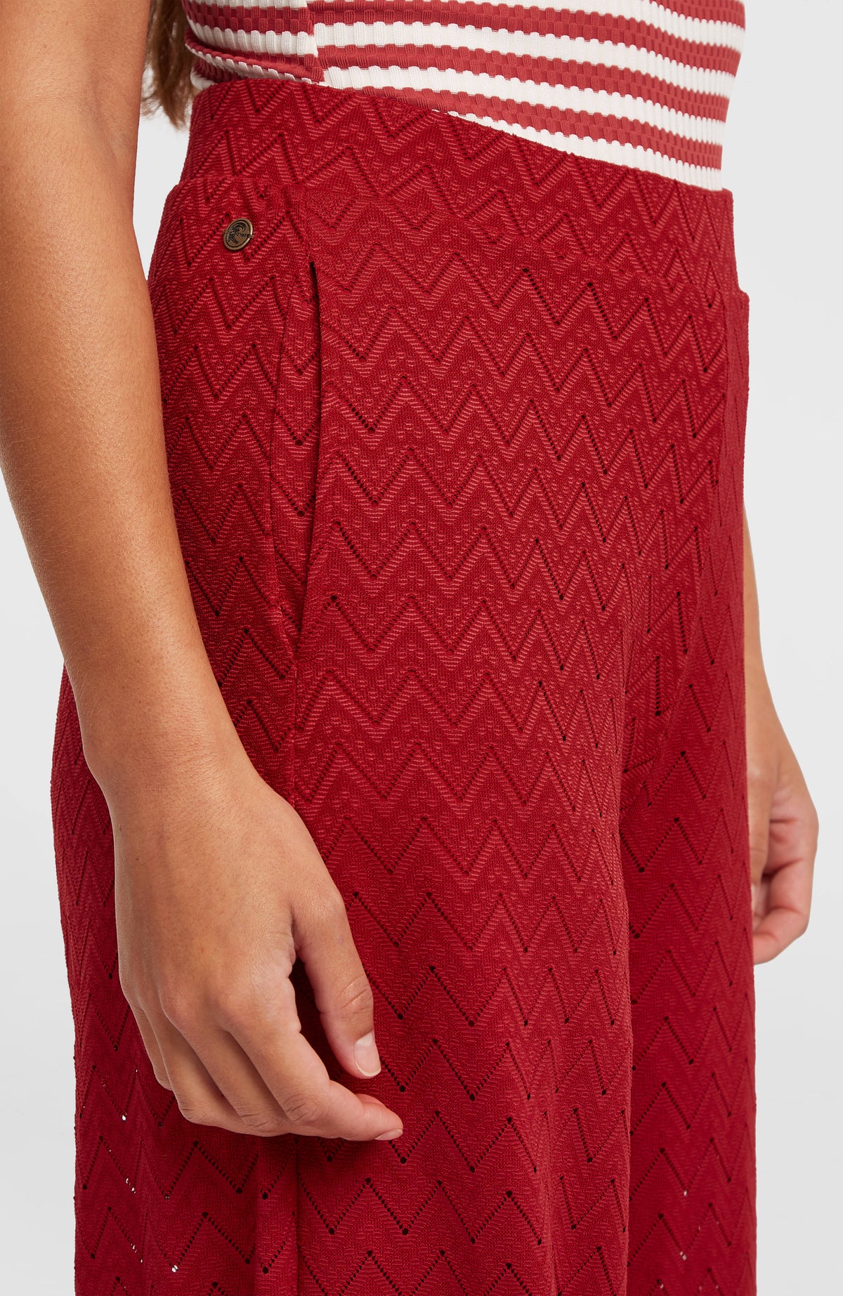 Nahaufnahme von Bund, Seitentasche und Logo-Badge der roten O'Riginals Wide-Leg Hose