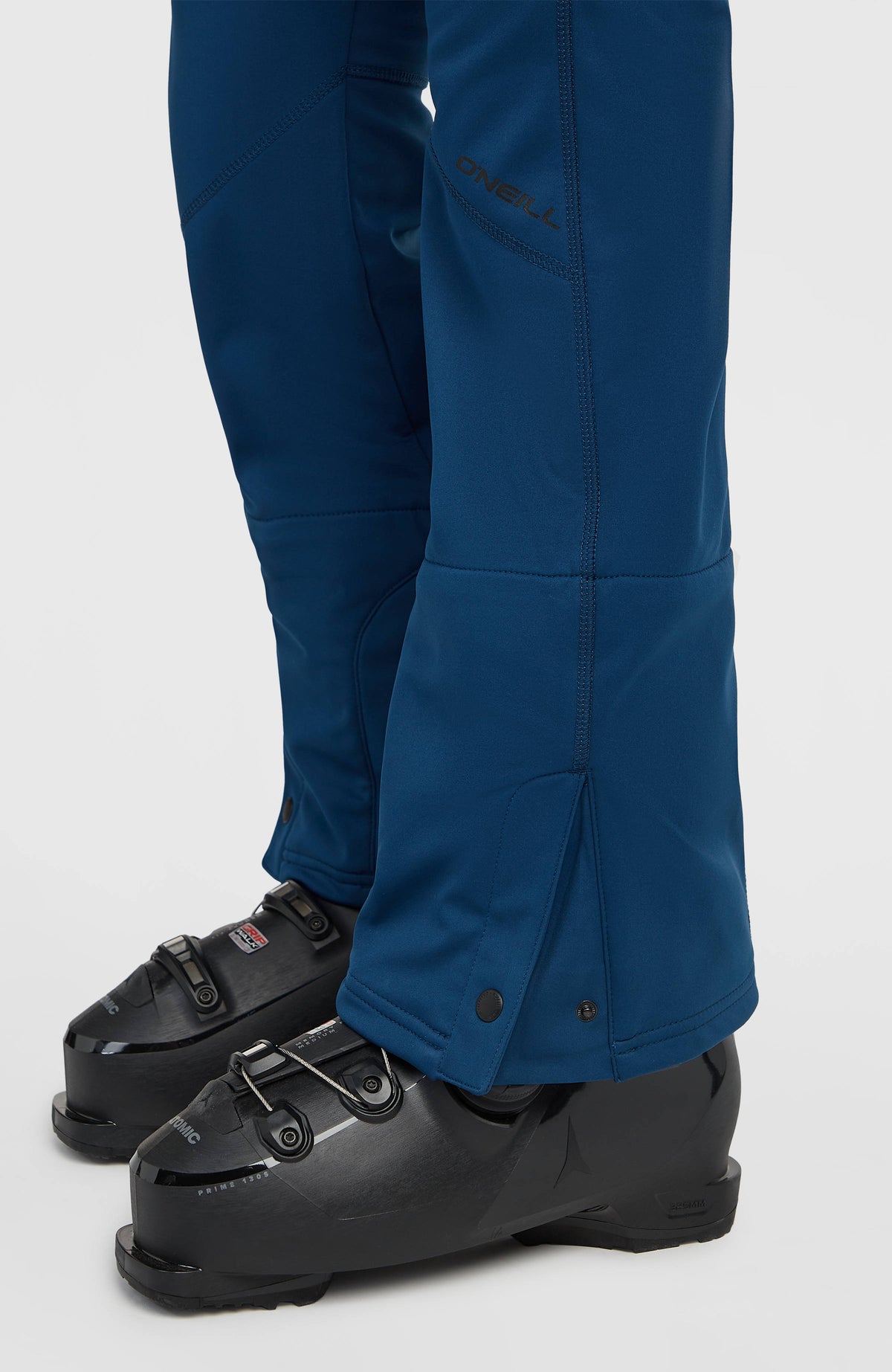 Nahaufnahme vom Hosenbein und Beinsaum mit Druckknopf der blauen FWC'Cruz Softshell-Skihose für Damen