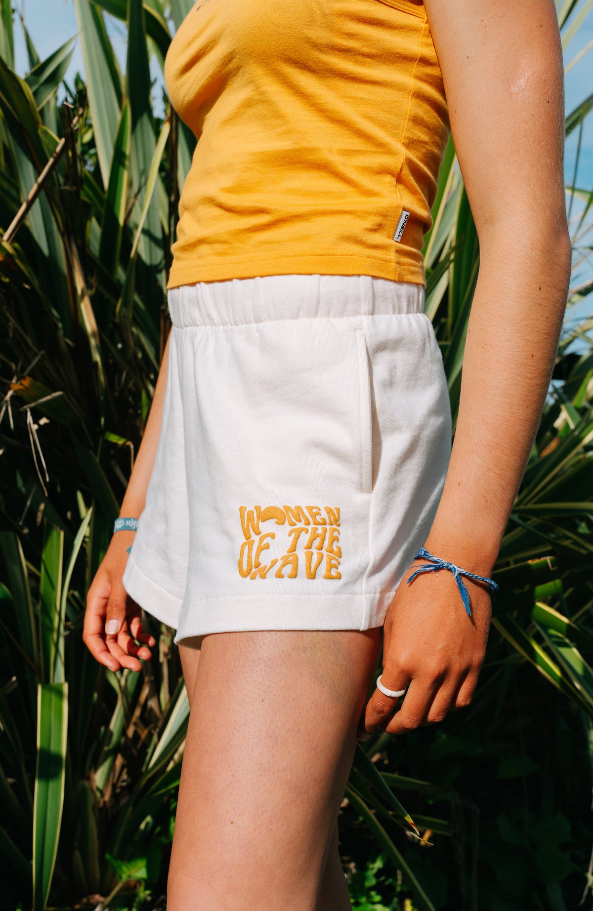 Women of the Wave Sweatshorts für Damen, beige, im Freien vor Pflanzen am Model, seitliche Ansicht