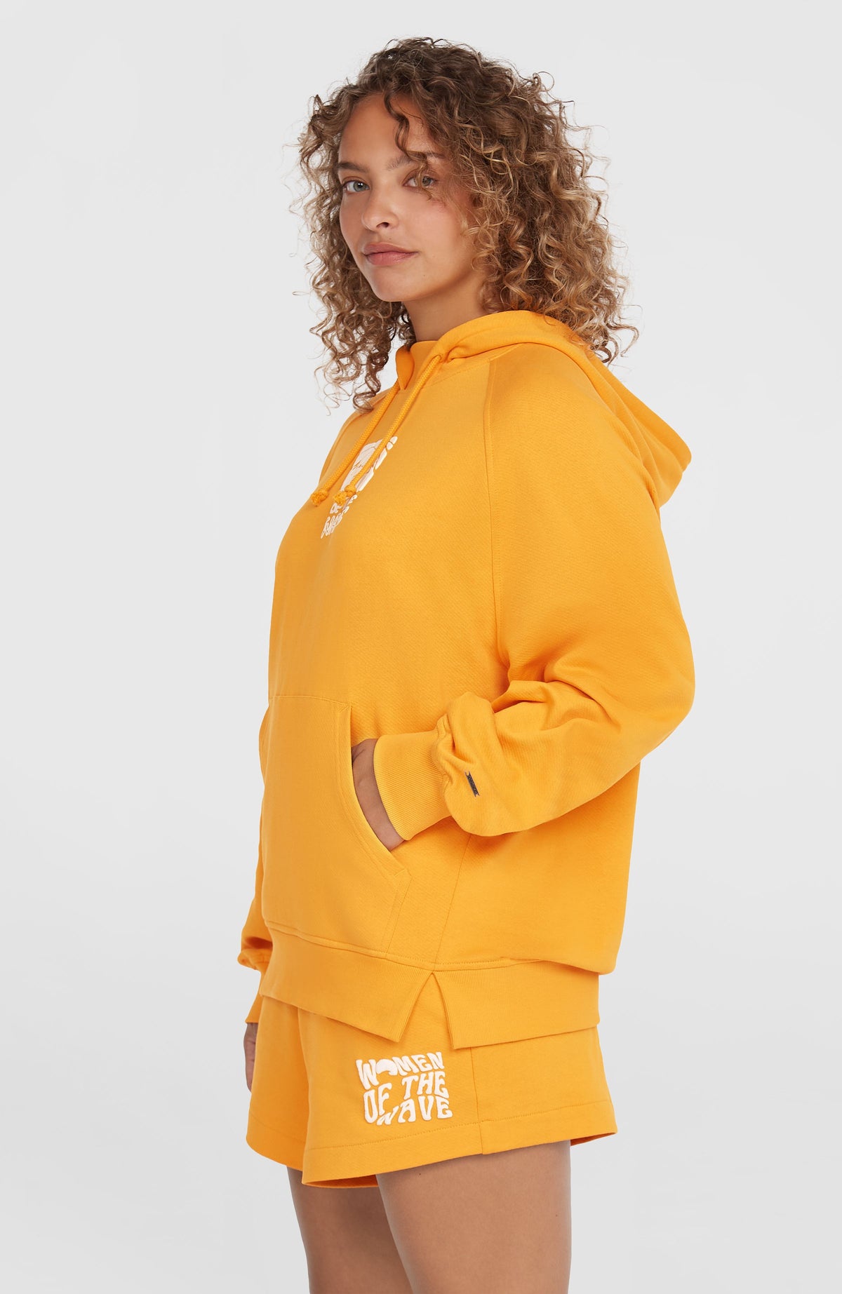 Women of the Wave Hoodie für Damen, orange mit Grafik-Print in Weiß, getragen am Model, Seitenansicht