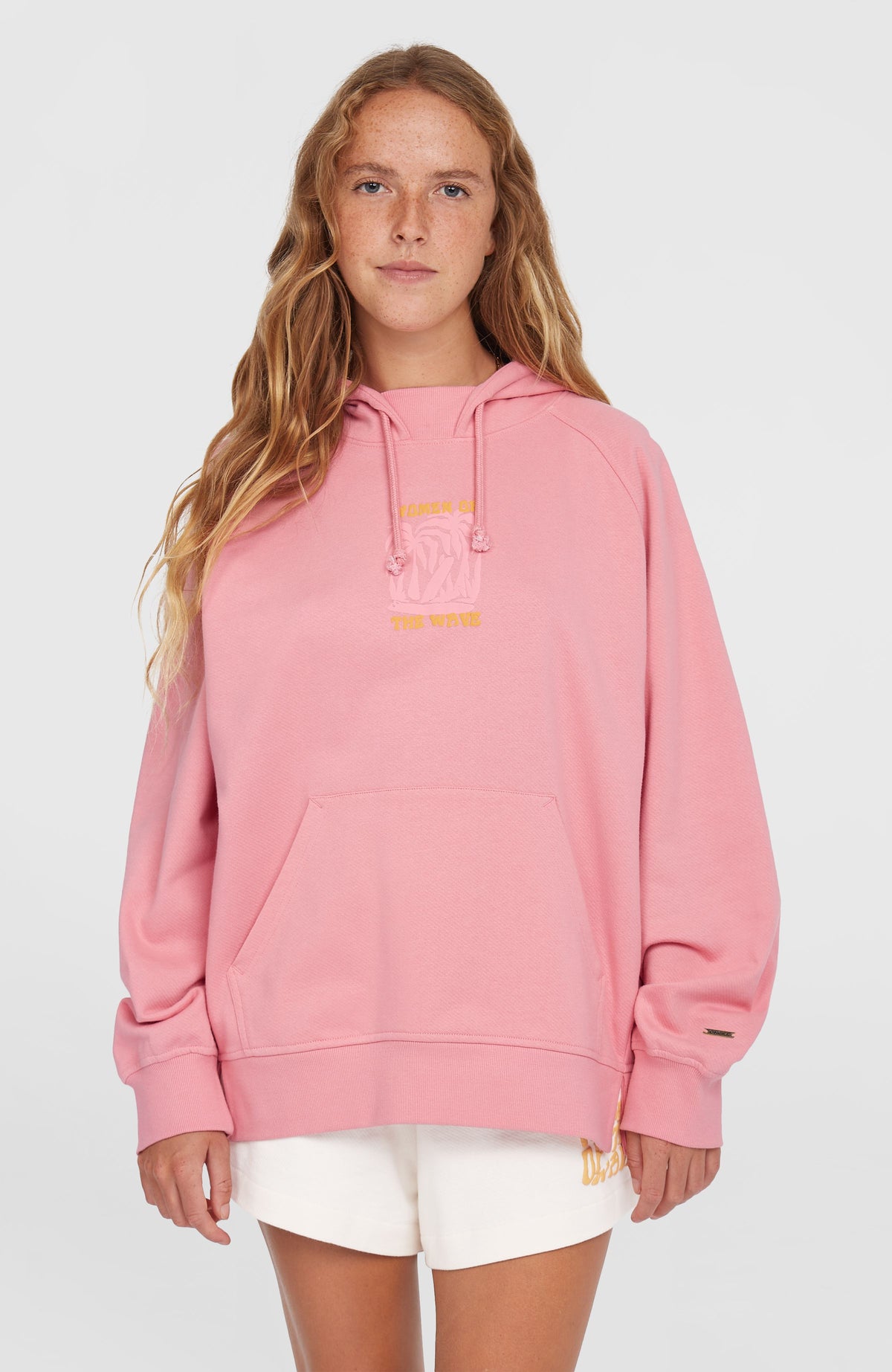 O'Neill Women of the Wave Hoodie für Damen, pink mit Grafik-Print in Gelb, Vorderansicht am Model mit Kängurutasche