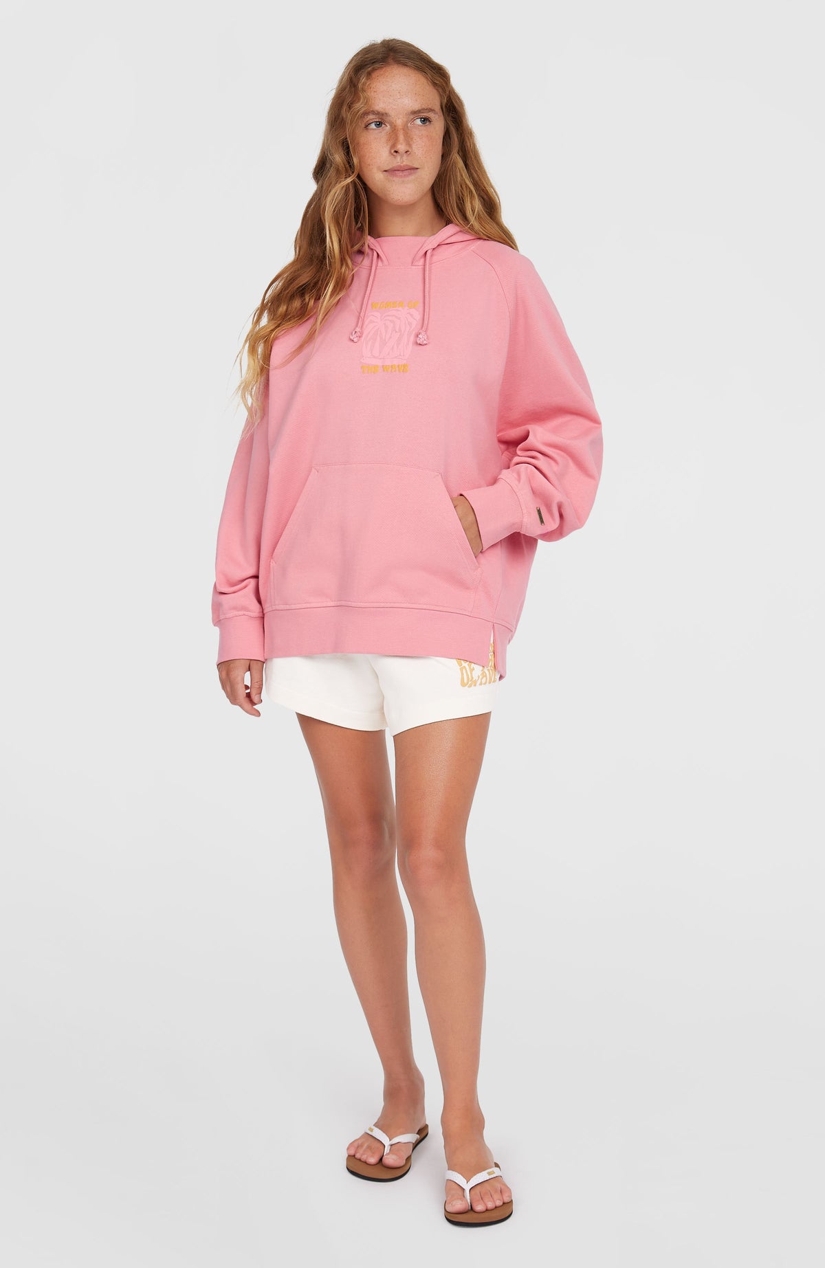 Women of the Wave Hoodie für Damen, pink mit Grafik-Print in Gelb, stehend am Model in der Ganzkörperansicht