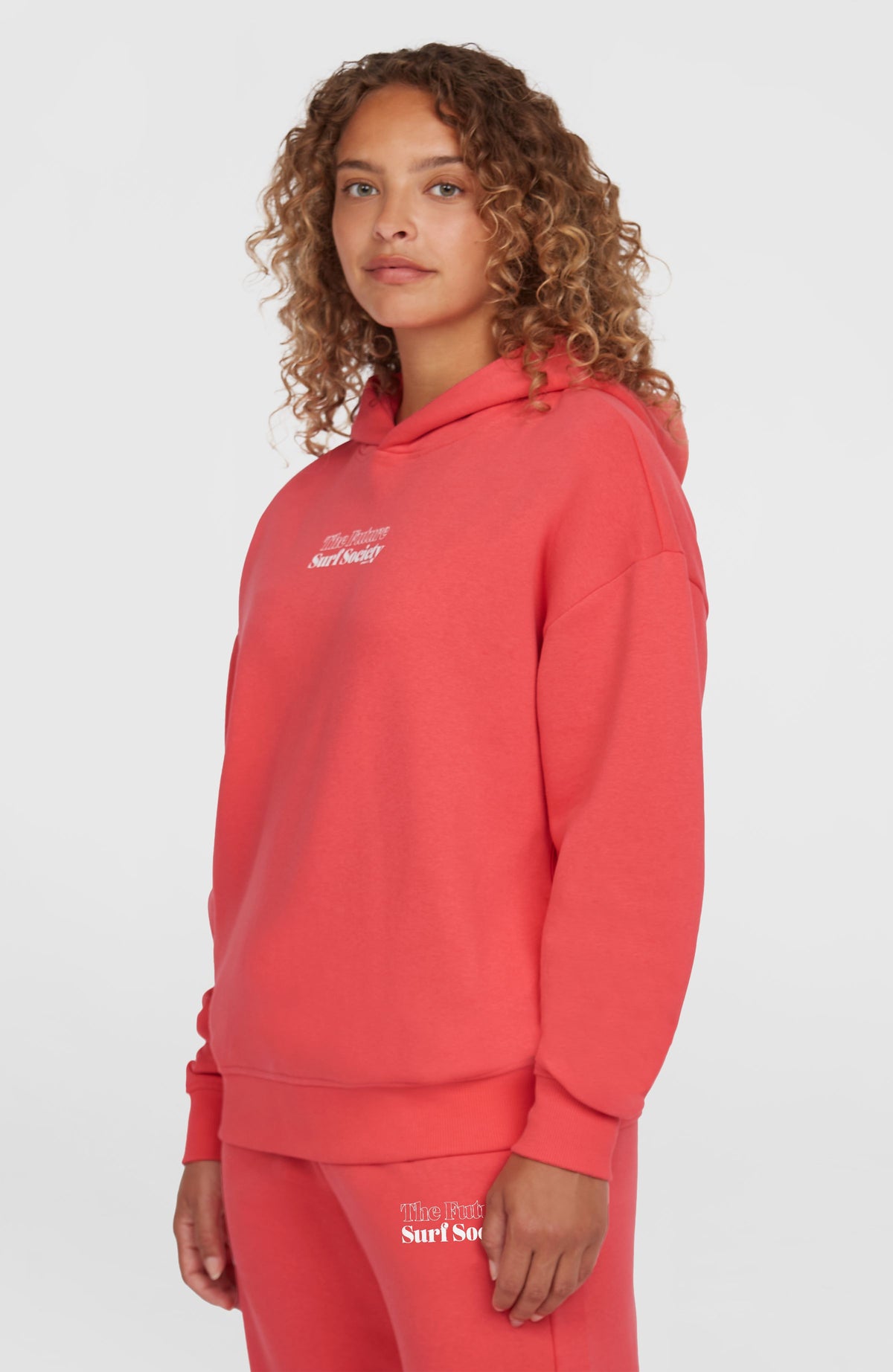 Future Surf Society Hoodie für Damen, pink mit Logo-Print in Weiß, Halbprofilansicht am Model