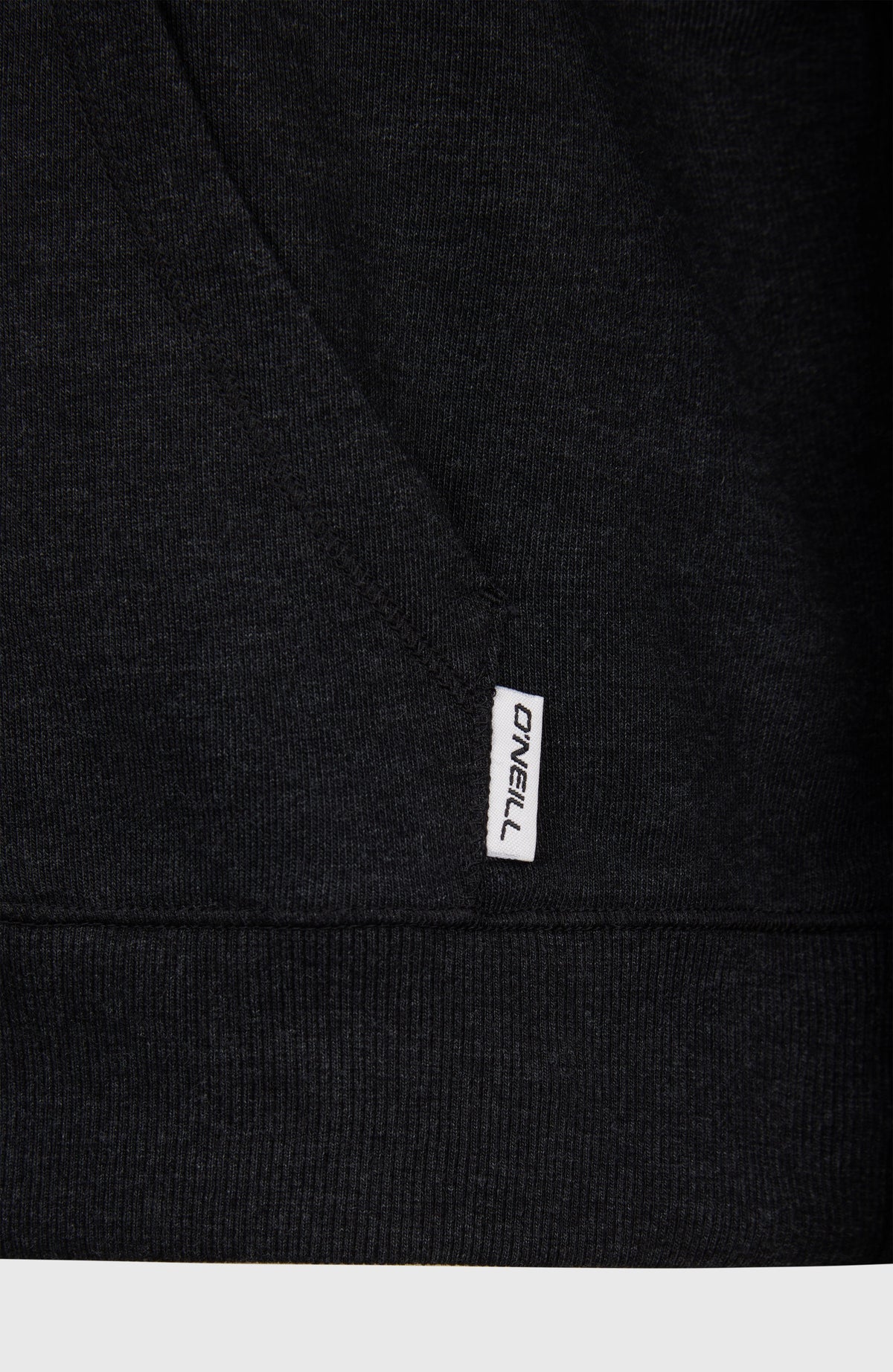 Nahaufnahme von Saum und kleinem Logo-Label am unteren Rand des schwarzen Essentials O'Neill Script Hoodie