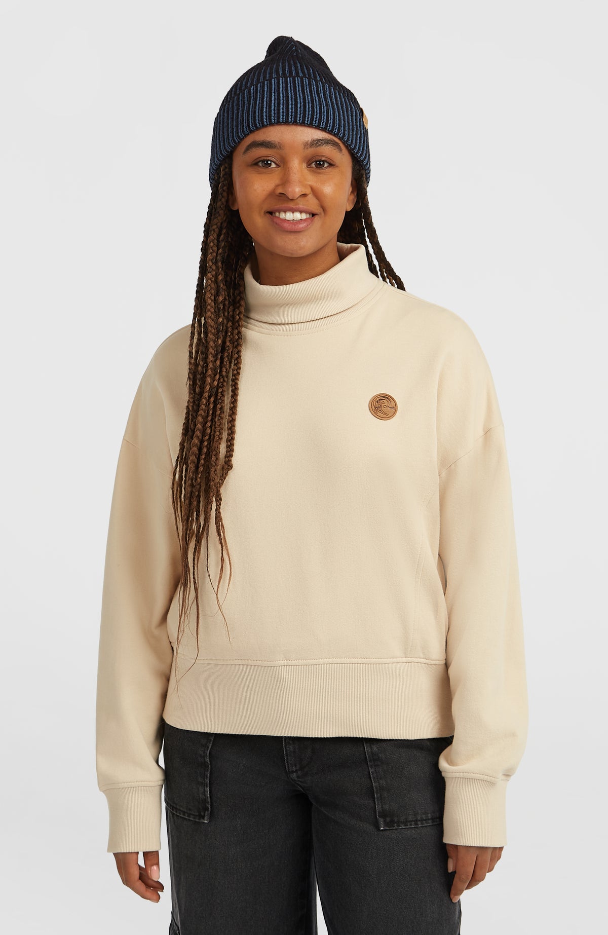 O'Riginals Crew Sweatshirt für Damen in Beige, Vorderansicht am Model mit rundem Logo-Patch auf der Brust