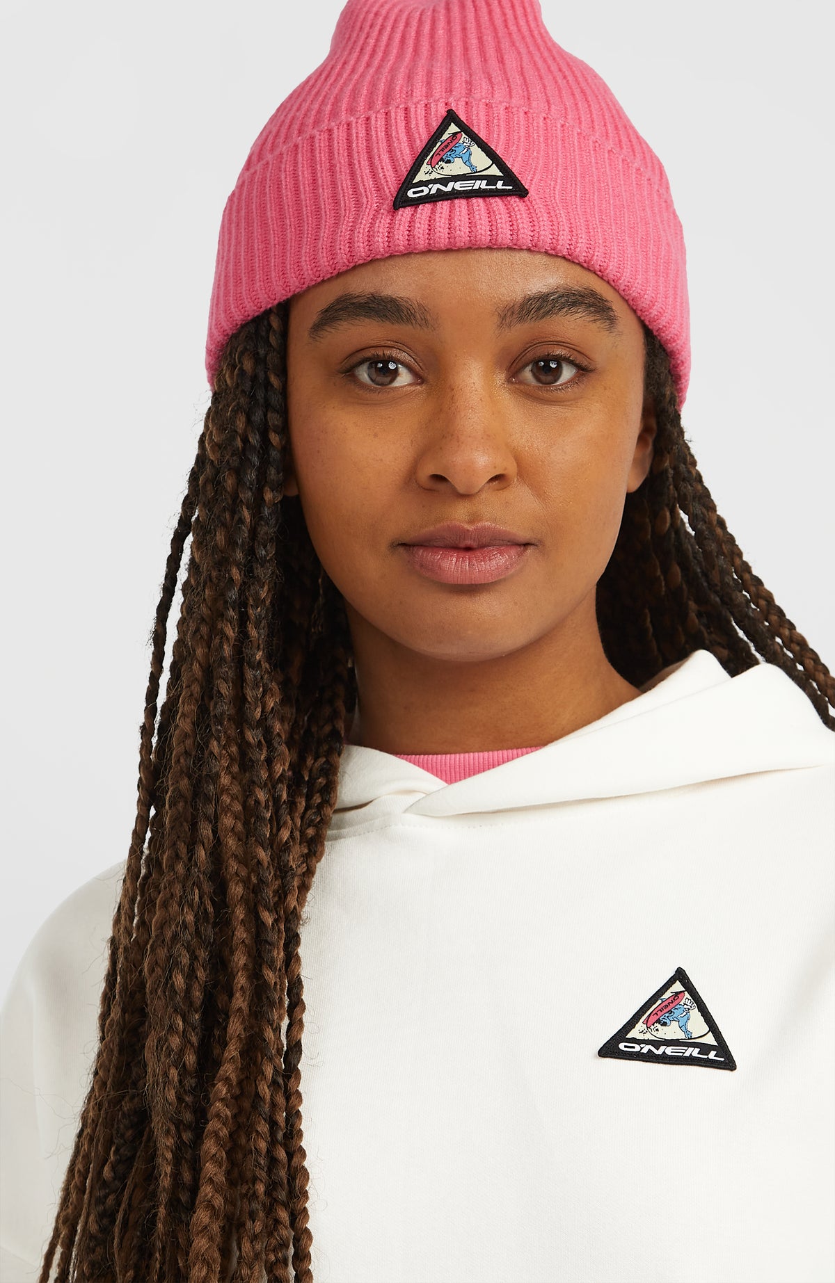 FWC'Play Hoodie für Damen, weiß mit Logo-Print in Blau und Pink, Nahaufnahme am Model mit dreieckigem Logo-Patch