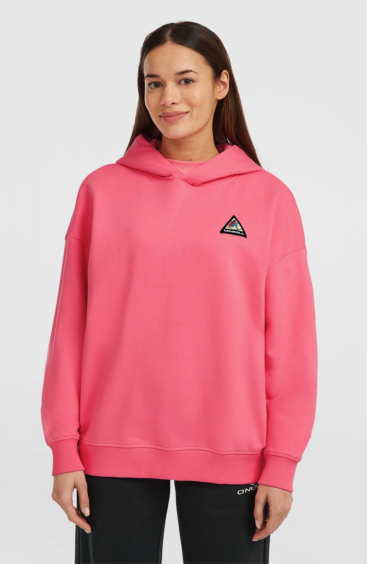 O'Neill FWC'Play Hoodie für Damen in Pink, Vorderansicht am Model mit dreieckigem Logo-Aufnäher auf der Brust