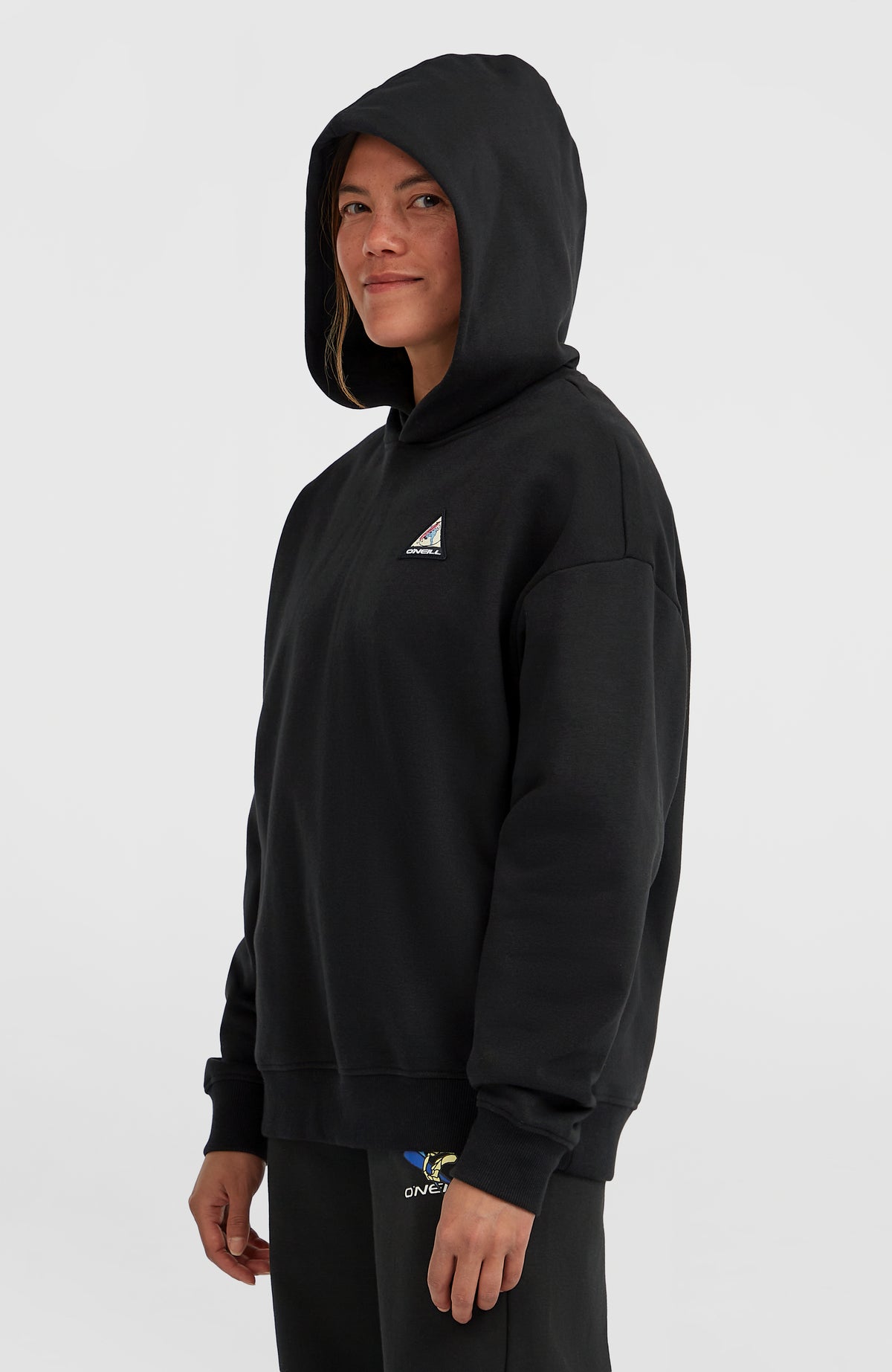 FWC'Play Hoodie für Damen, schwarz, getragen am Model in Halbprofilansicht mit aufgesetzter Kapuze