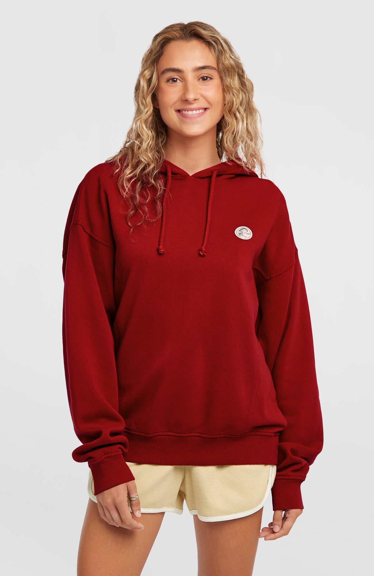 O'Neill O'Riginals Hoodie für Damen, rot, Vorderansicht getragen am Model mit Kordelzug und rundem Logo-Patch