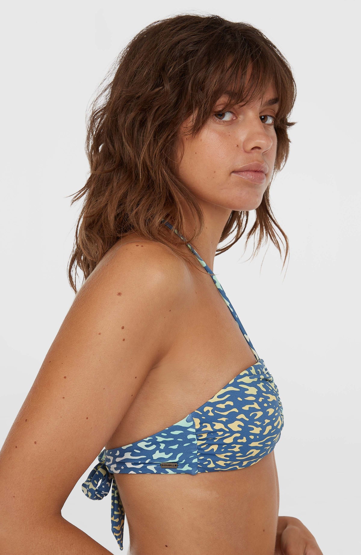 Embry Bikini-Oberteil für Damen, gelb mit Tiermuster in Blau, Seitenansicht am Model mit kleinem Logo-Badge