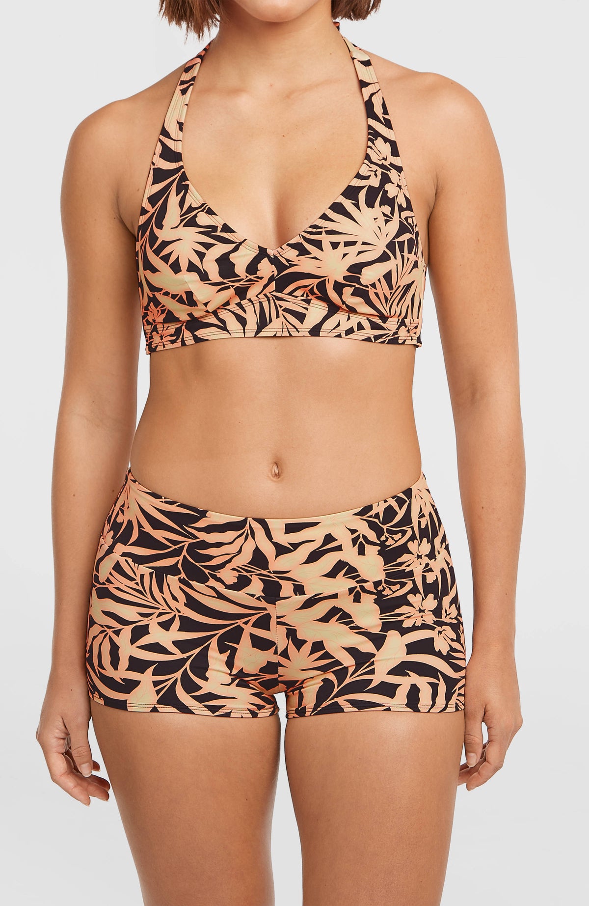 Grenada Bikinihose für Damen, schwarz mit Blättermuster in Orange, Vorderansicht am Model