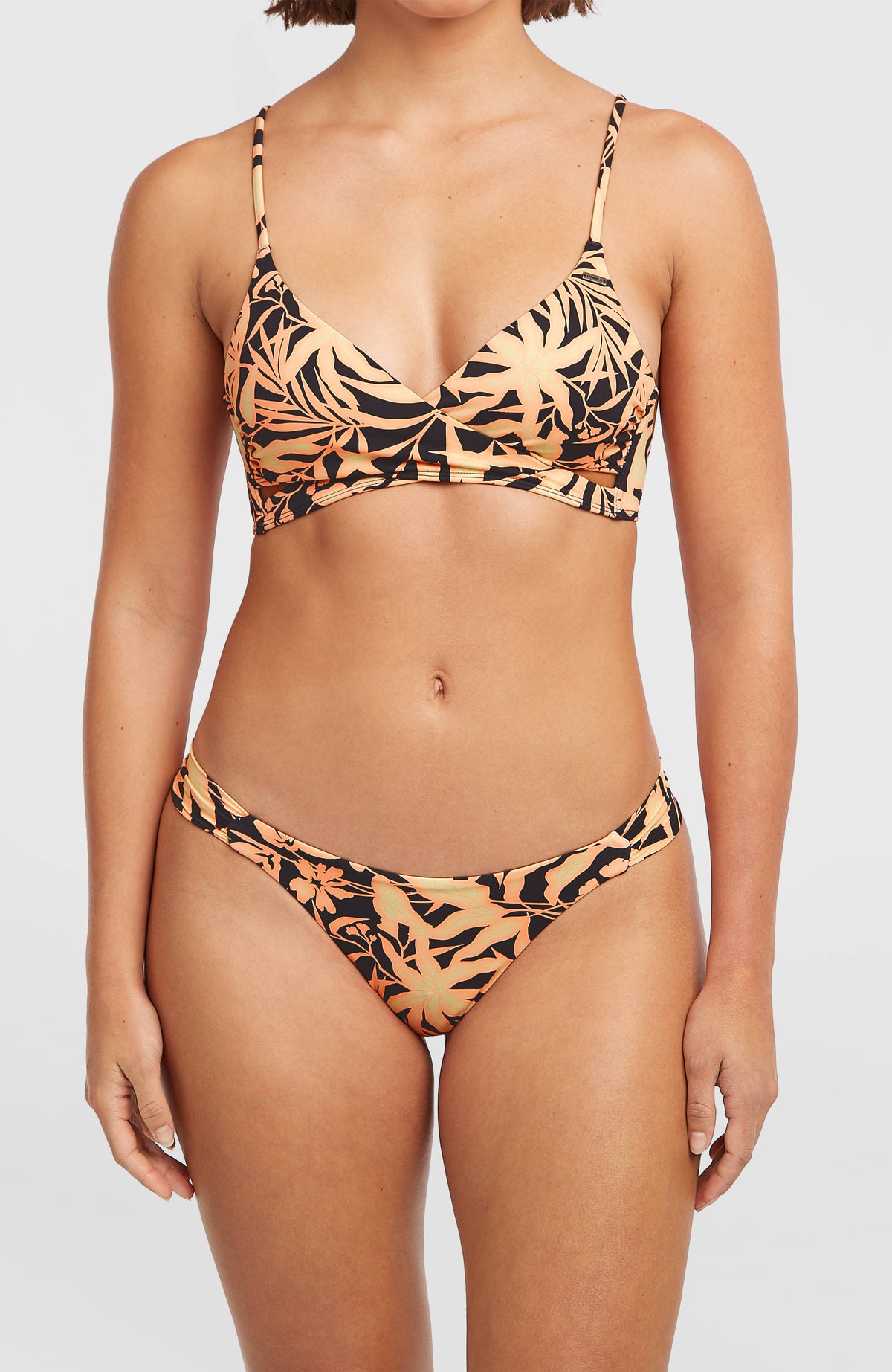 Kee Bikinihose für Damen, schwarz mit Pflanzenmuster in Orange, Nahaufnahme der Vorderseite am Model