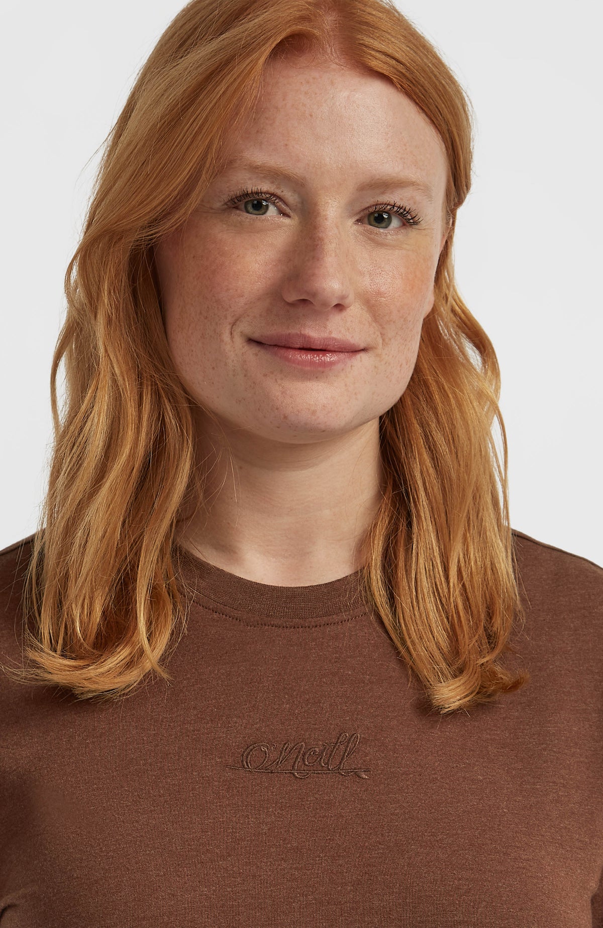 Nahaufnahme des Rundhalsausschnitts und der Logo-Stickerei am braunen Essentials Script T-Shirt für Damen