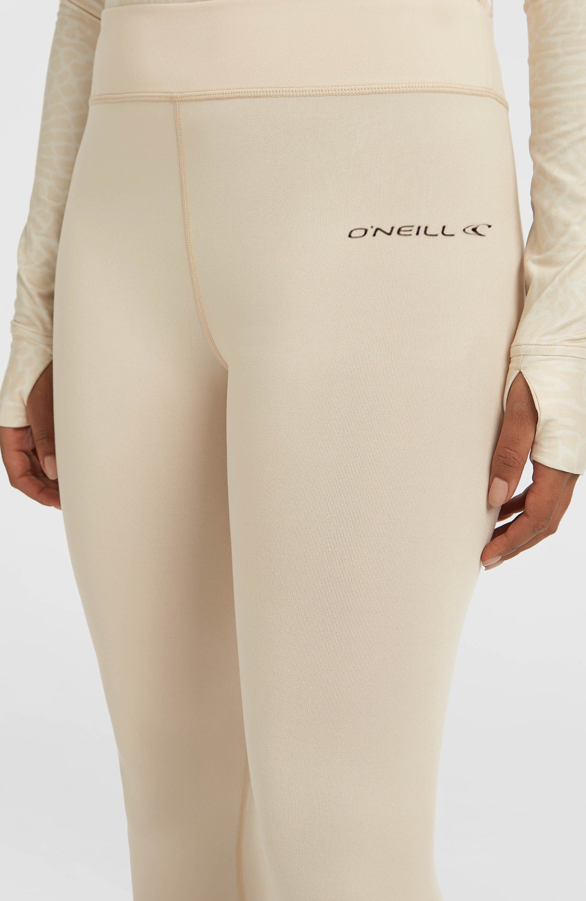 Nahaufnahme von Bund und Logo-Schriftzug der beigen Thermounterhose am Model
