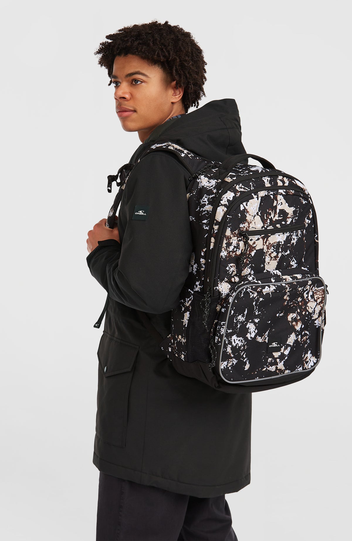 President Rucksack für Herren, schwarz mit Marmormuster in Beige und Weiß, getragen am Model von der Seite