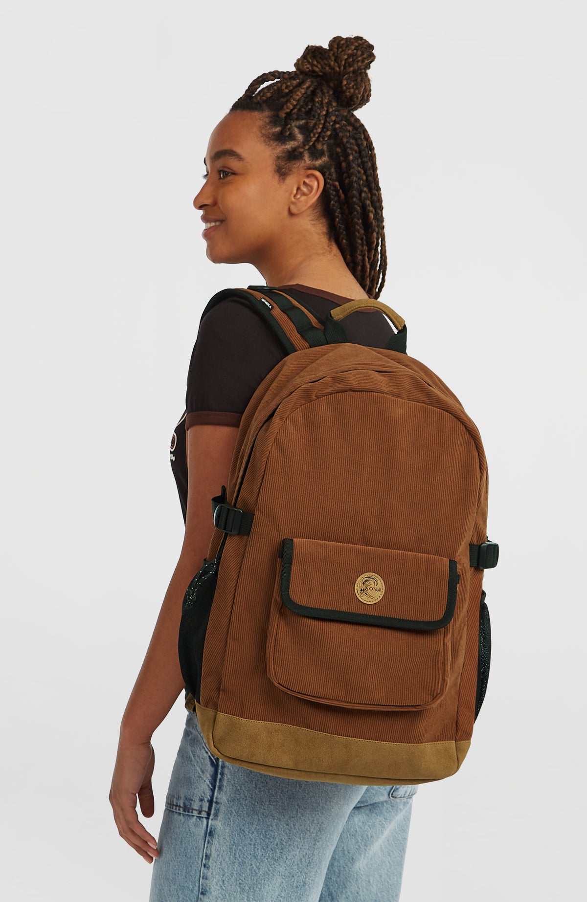 O'Riginals Rucksack, braun, getragen am Model in halber Rückenansicht mit Vordertasche und Tragegriff