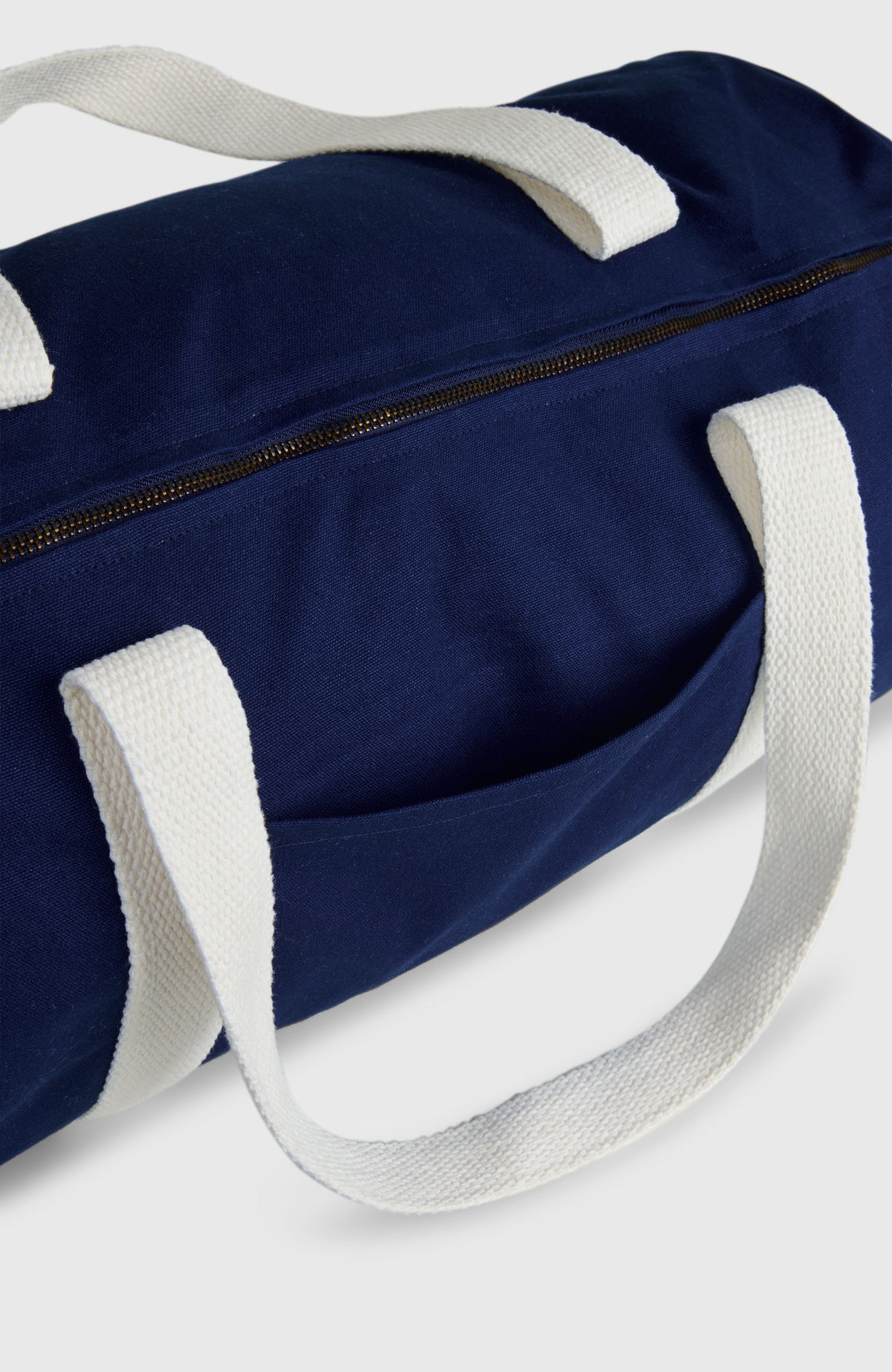 Nahaufnahme von Reißverschluss und Einsteckfach der blauen O'Riginals Tasche mit Logo-Print in Weiß