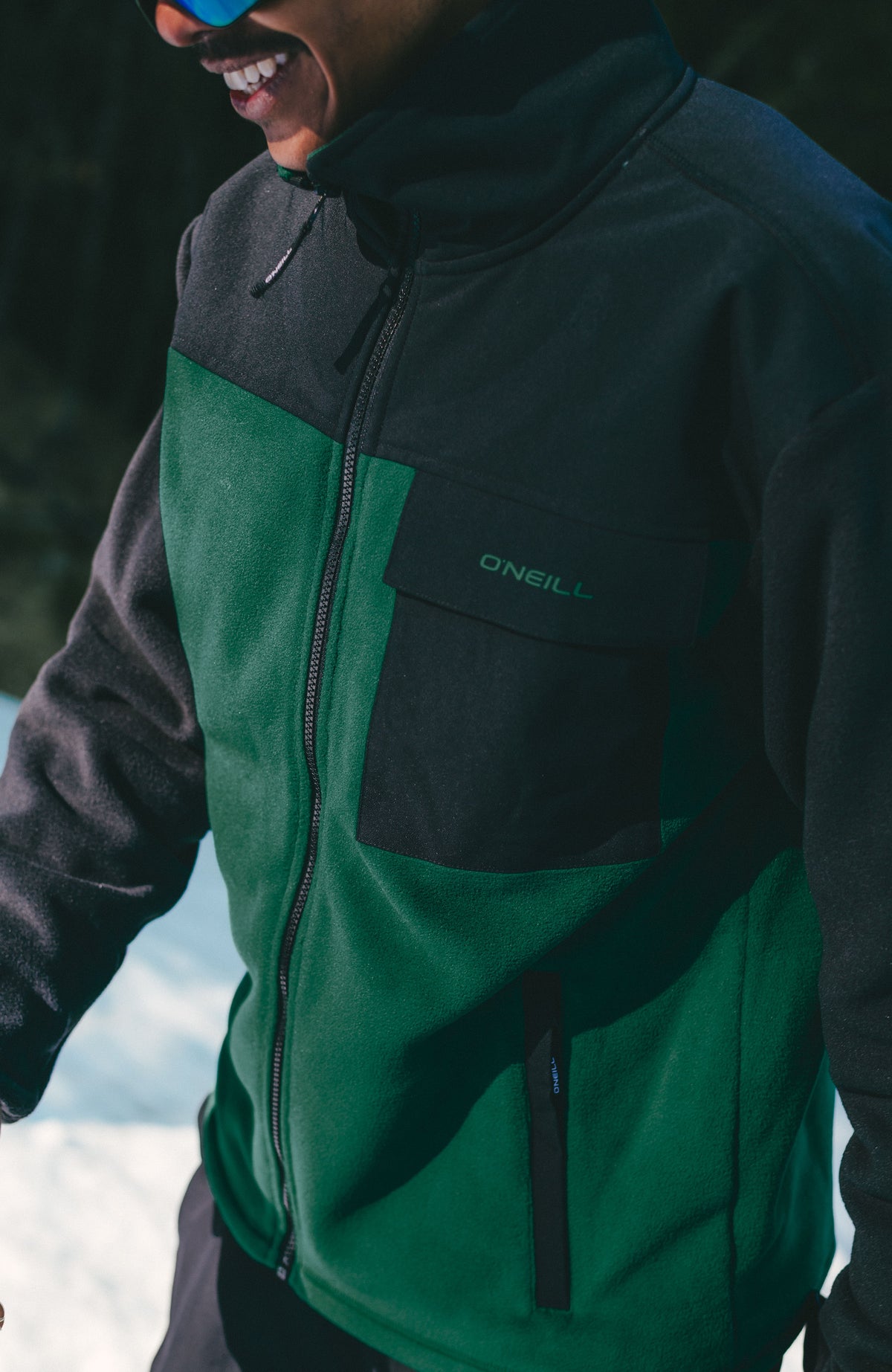 FWC'Peak Polartec® Fleecejacke, grün, im Schnee, Nahaufnahme der Brusttasche mit Logo-Print