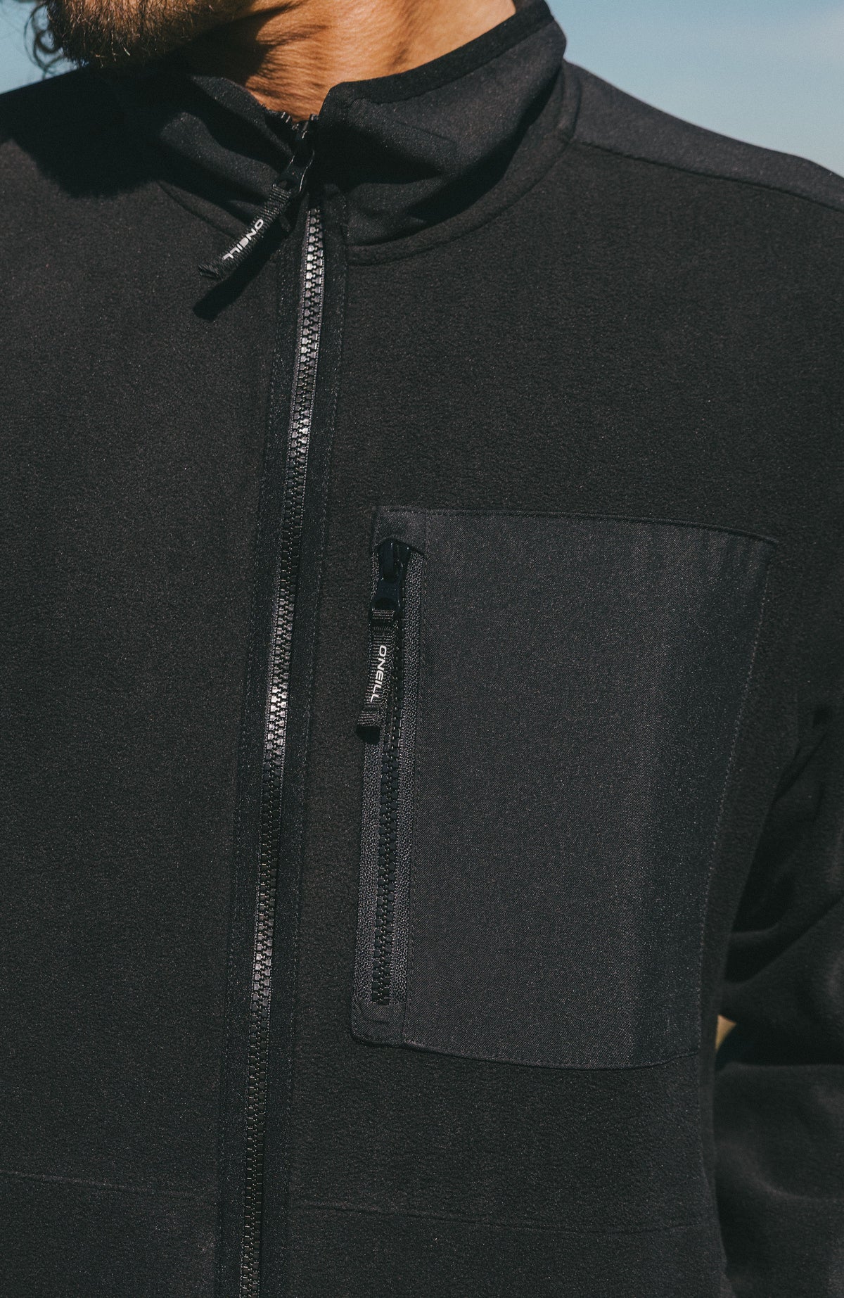 FWC'Play Polartec® Fleecejacke, schwarz, Nahaufnahme von Frontreißverschluss und Reißverschlusstasche