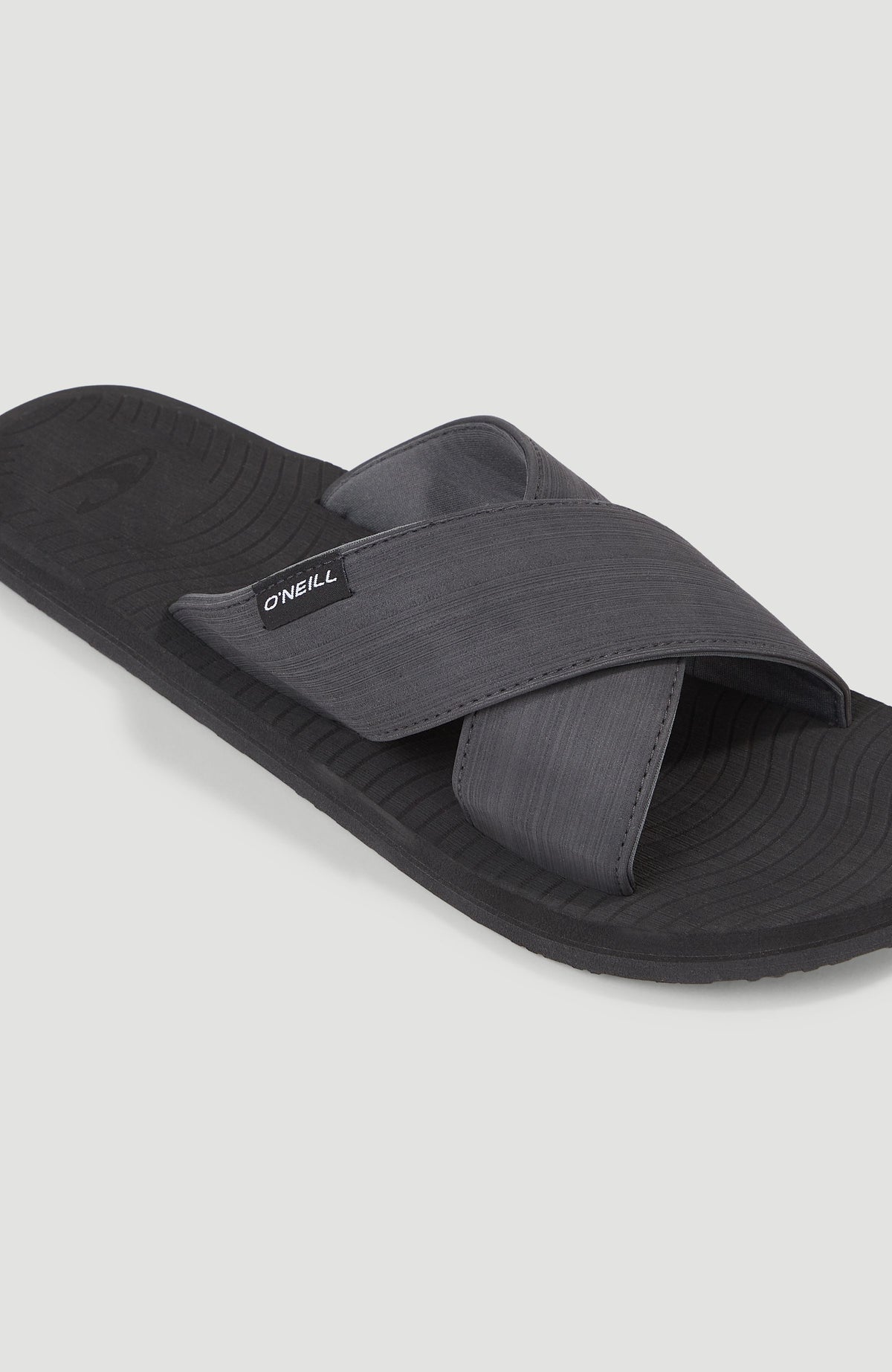 Koosh Crossover BLOOM™ Slides für Herren, schwarz, Nahaufnahme der gekreuzten Riemen mit Logo-Label