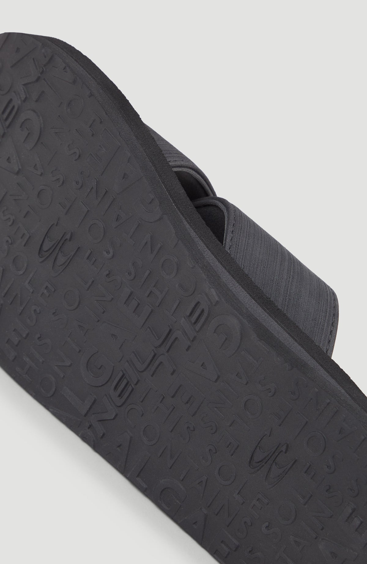 Nahaufnahme der profilierten Unterseite der schwarzen Koosh Crossover BLOOM™ Slides für Herren