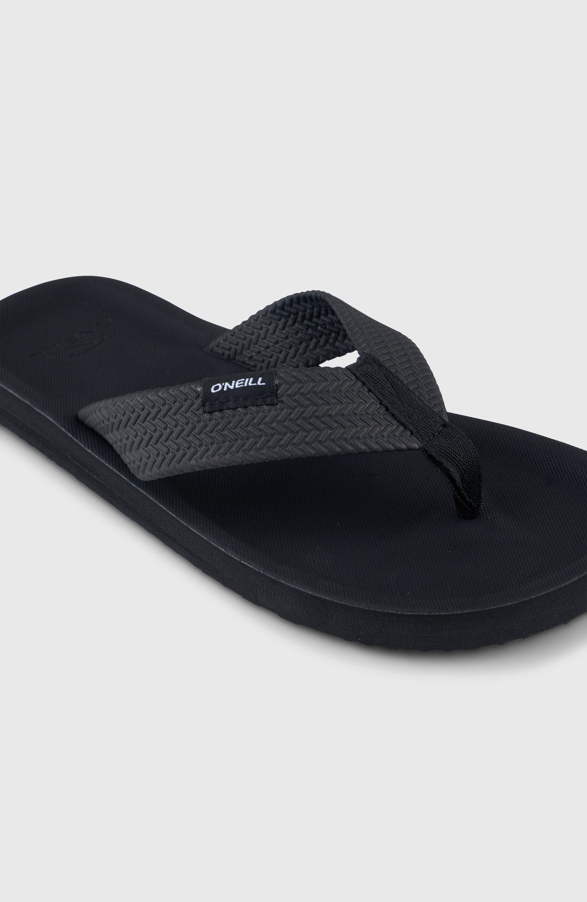 Nahaufnahme der schwarzen Chad Sandalen, gewebter Riemen mit Logo-Patch