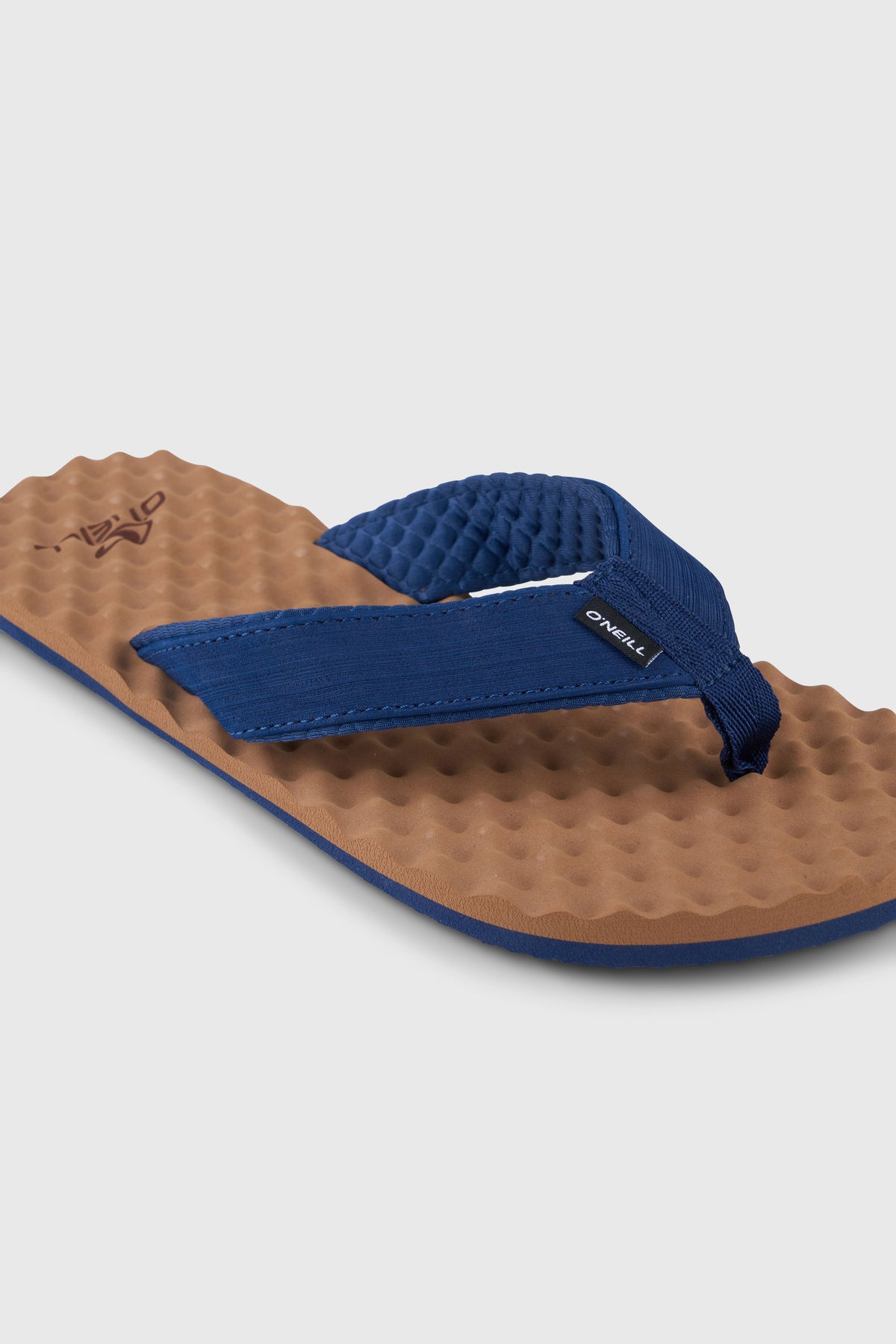 Nahaufnahme der braunen Koosh Pro Sandalen für Herren mit blauem Riemen und Logo-Label